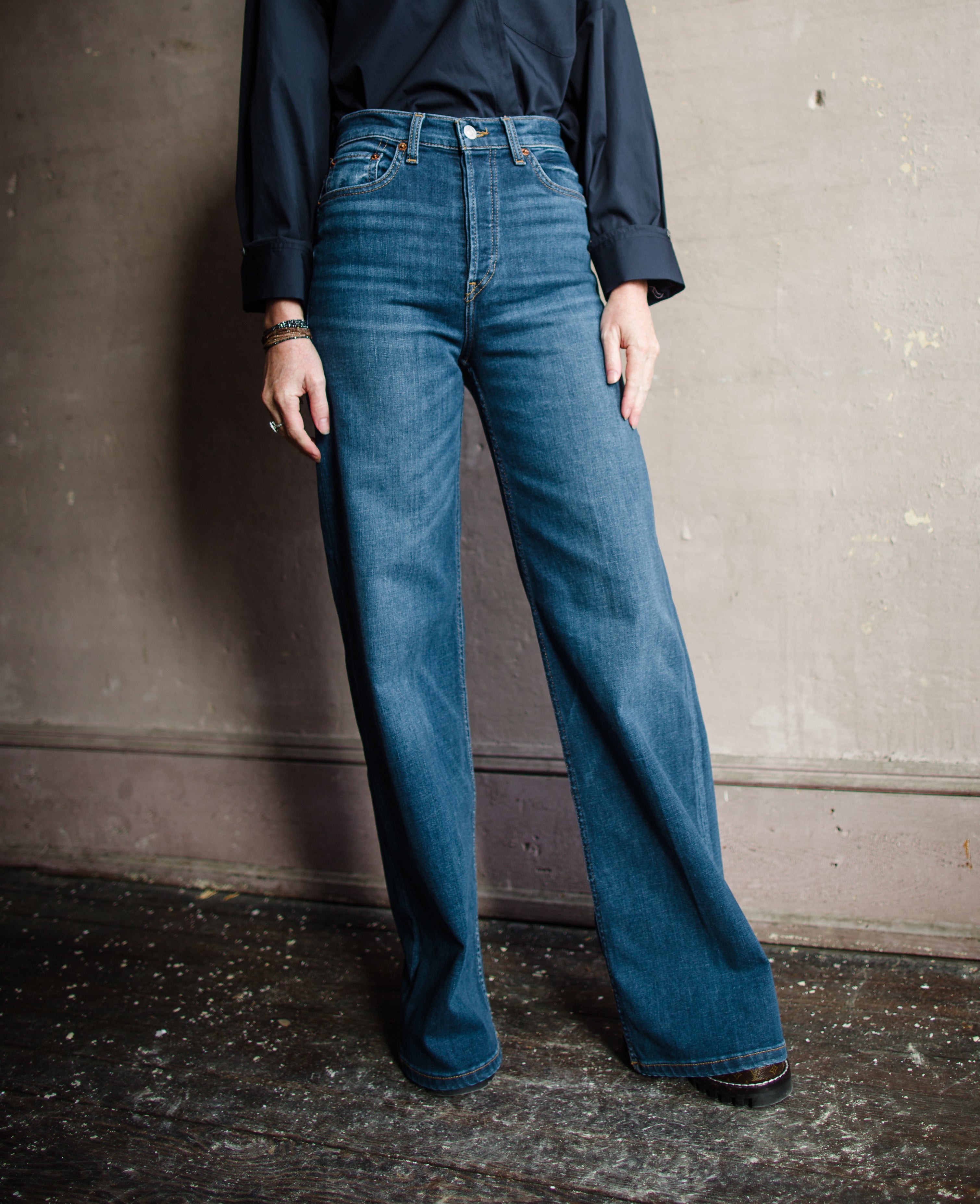 Image features woman wearing the 70's Ultra High Rise Wide Leg Jeans by Re/Done. Denim has a high rise and wide leg with a full length hem.