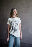 Image featuring a woman wearing the cotton Rodeo tee by Re/Done with a crew neckline and vintage Beverly Hills CA cowgirl on horseback graphic in a relaxed cut body.