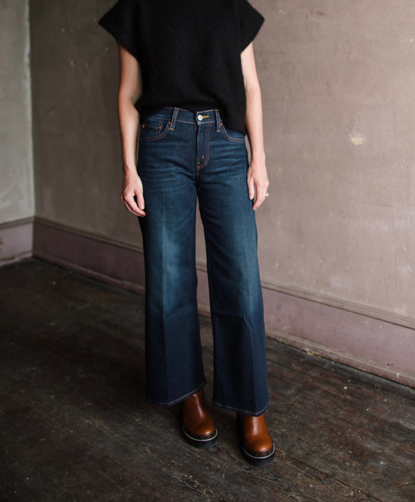 Image featuring a woman wearing  jeans by Re/Done with a mid rise and cropped, wide leg in barely worn finish.