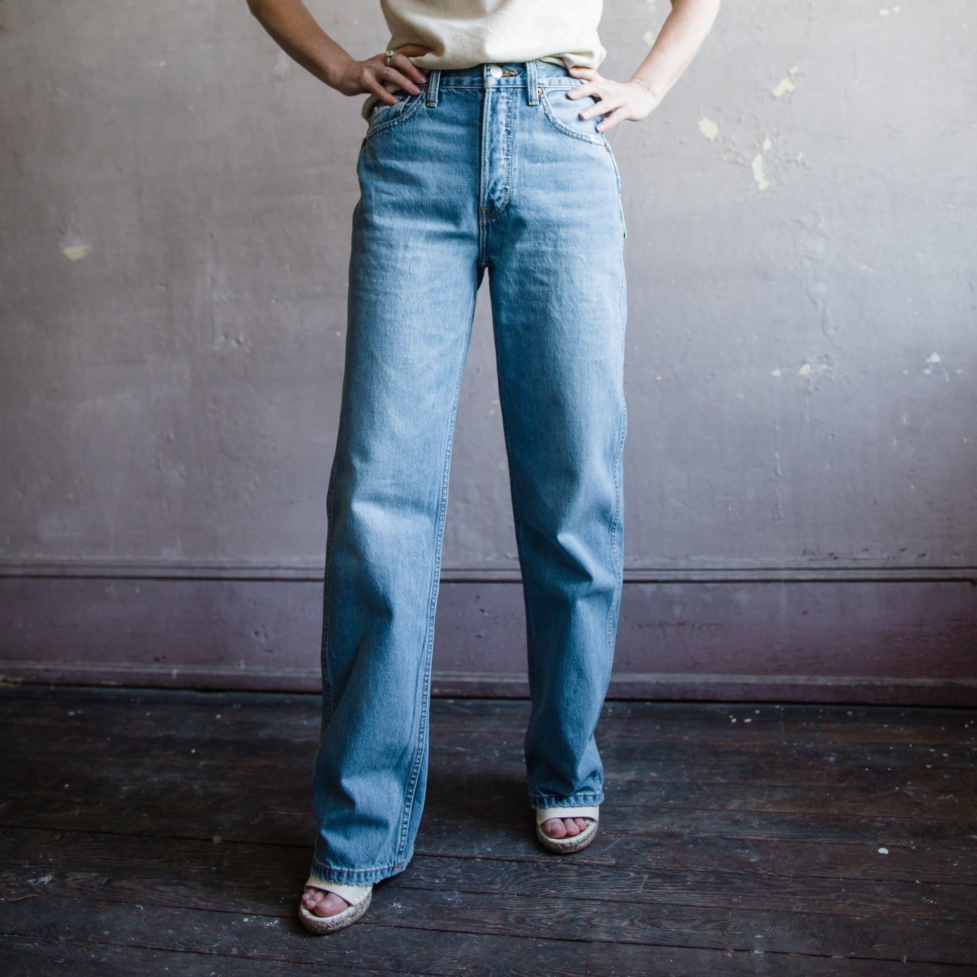 Image featuring a woman wearing Re/Done 90's high rise, straight leg, full length denim with small distressed details, and a classic button fly.