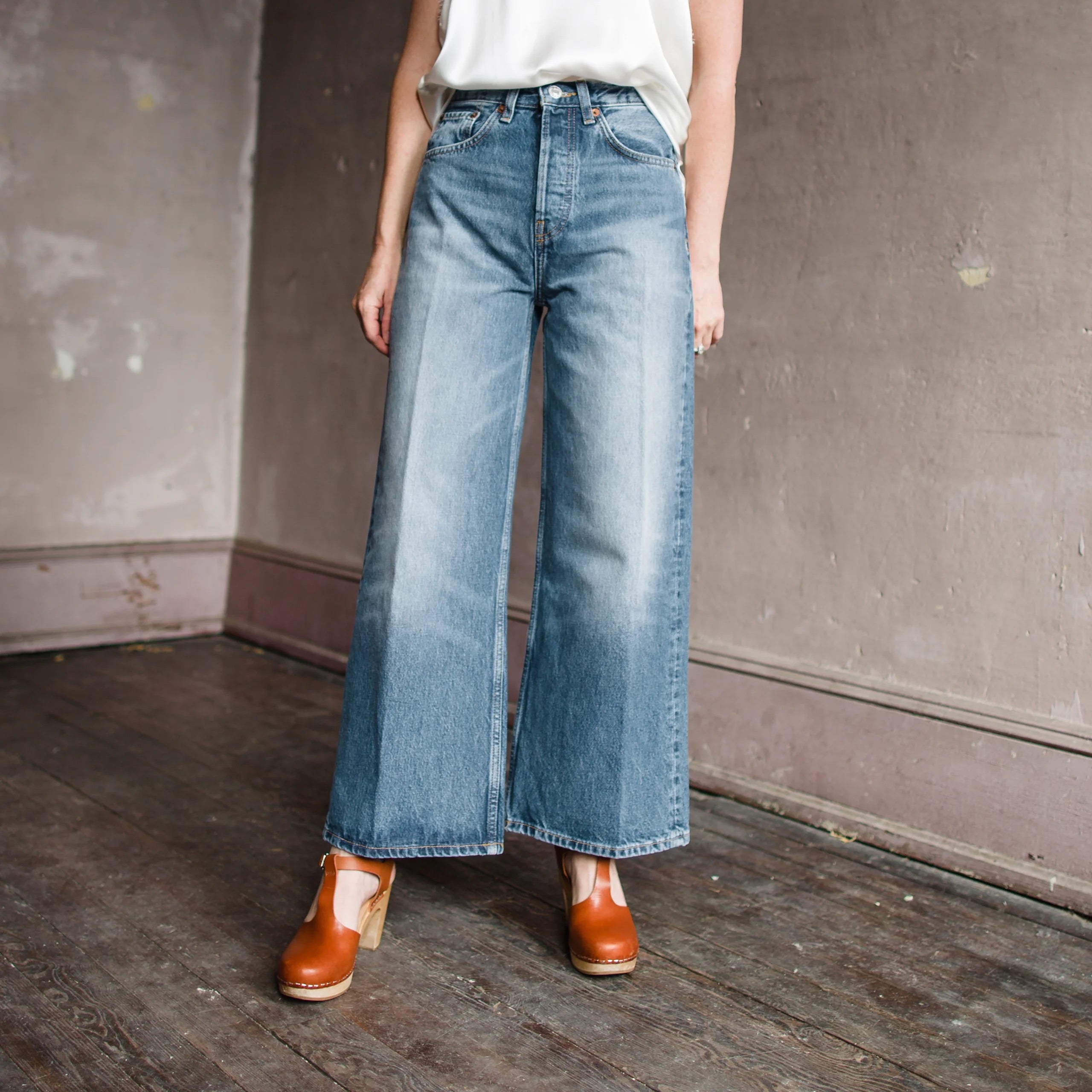 Image featuring a woman wearing Re/Done's High Rise Wide Leg Crop all-cotton jeans with five pocket style with button fly closure in speedway wash.