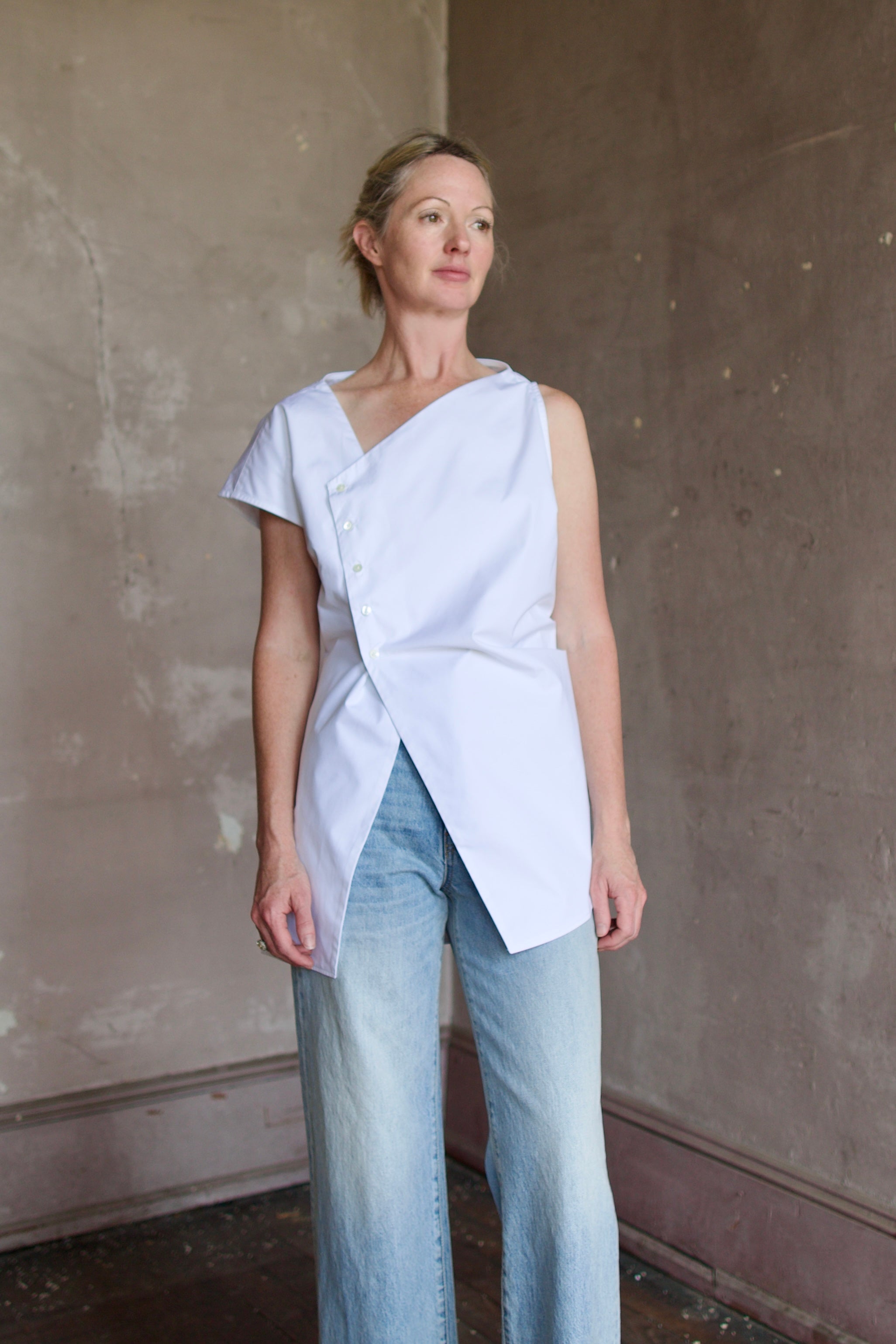 Model wearing cotton poplin shirt by Rohe with modern design and luxurious craftsmanship to elevate style with asymmetrical tailoring