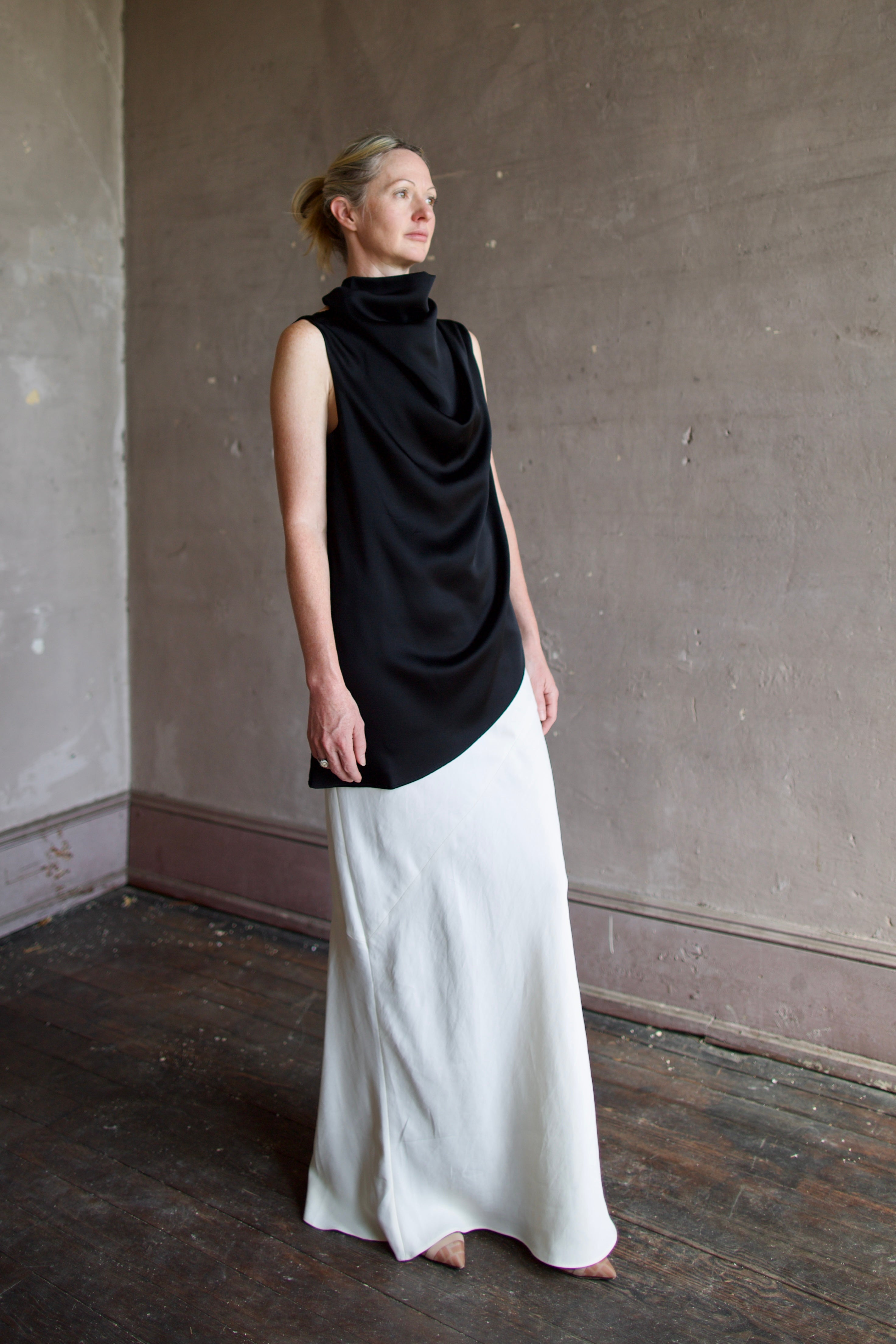 Model wearing black sleeveless satin top with expertly crafted draping by luxury modern designer Rohe