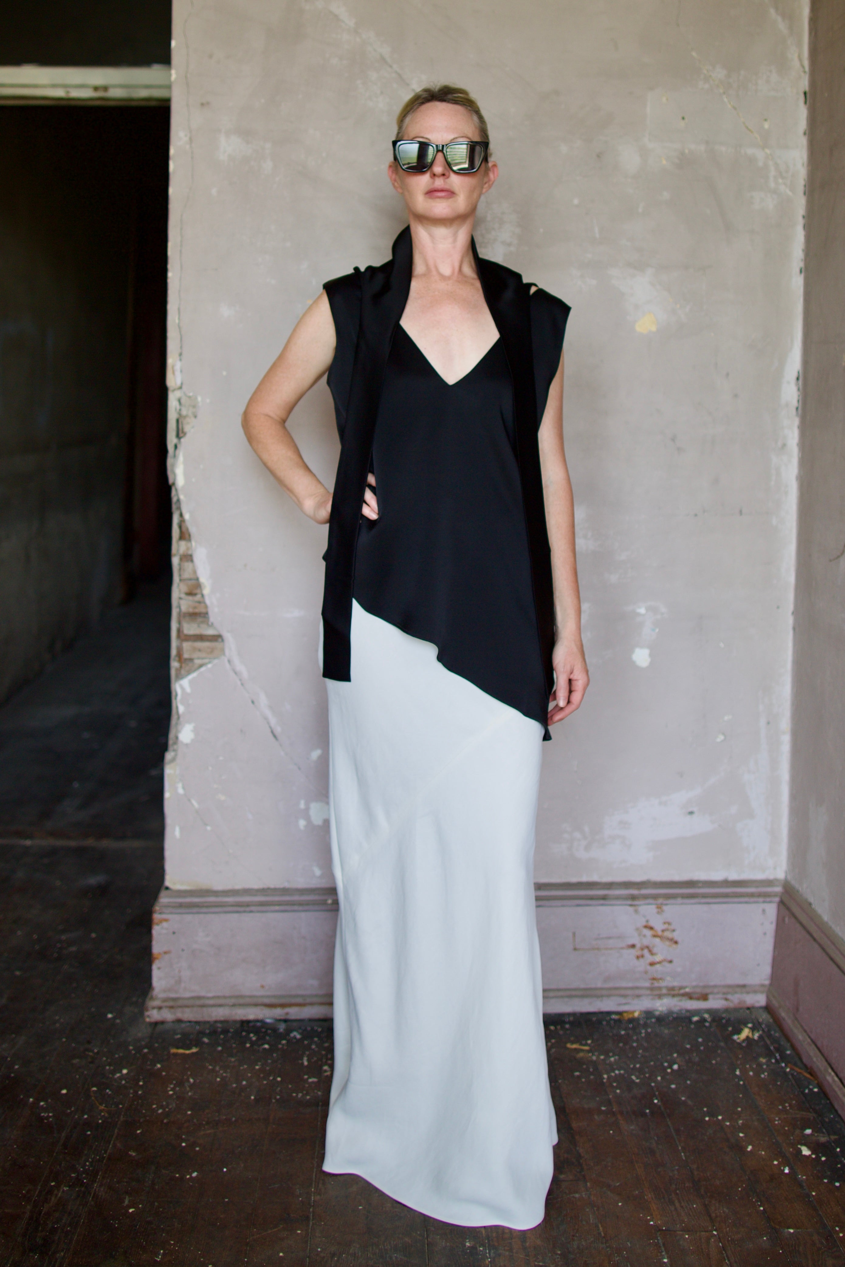 Model wearing reversible black sleeveless satin top with expertly crafted draping by luxury modern designer Rohe 