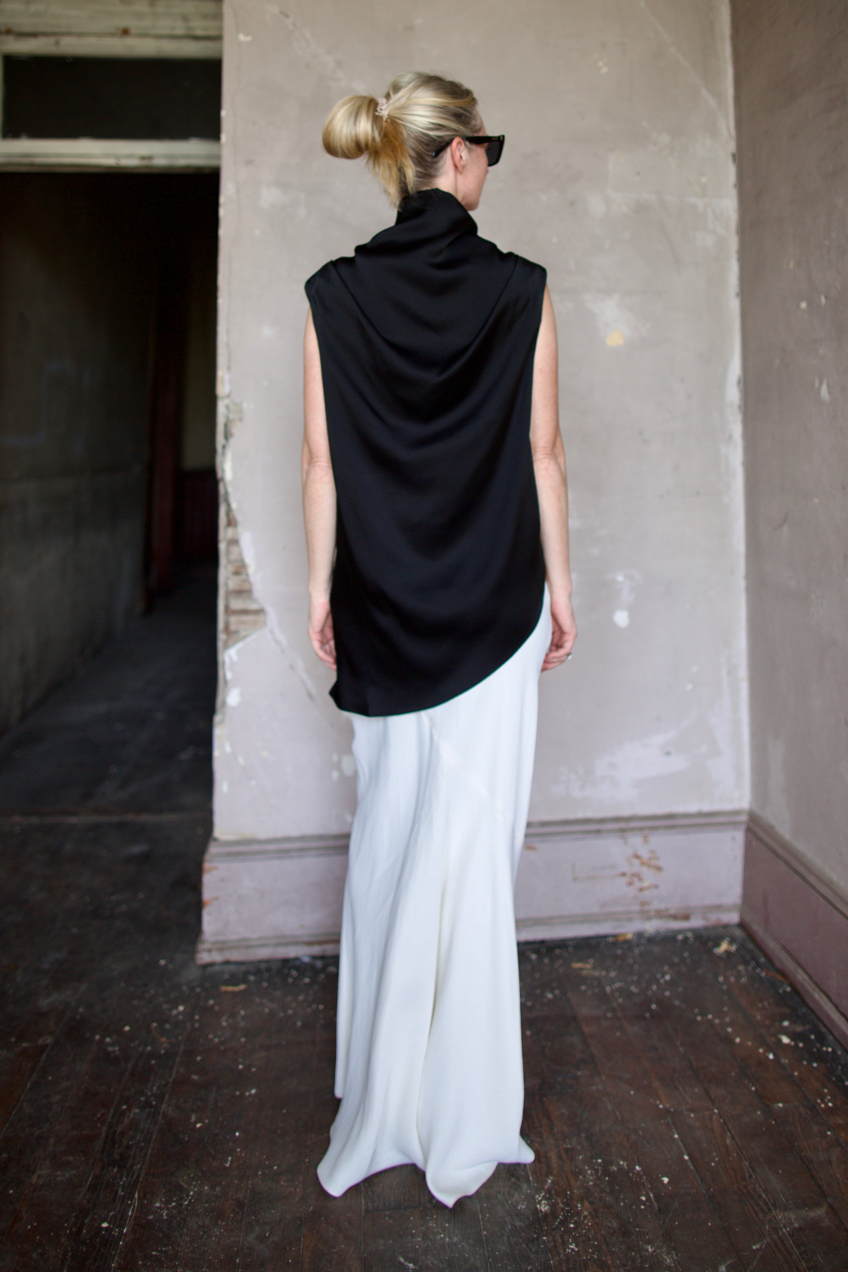 Model wearing black sleeveless satin top with expertly crafted draping by luxury modern designer Rohe