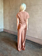 Woman wearing luxury brand SABLYN Grace Scallop Trim Bias Cut silk Maxi Pull On Skirt in neutral copper tone