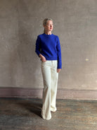 Mature woman wearing a vibrant cobalt blue Sablyn crewneck knit shrunken crewneck long sleeve cashmere sweater 