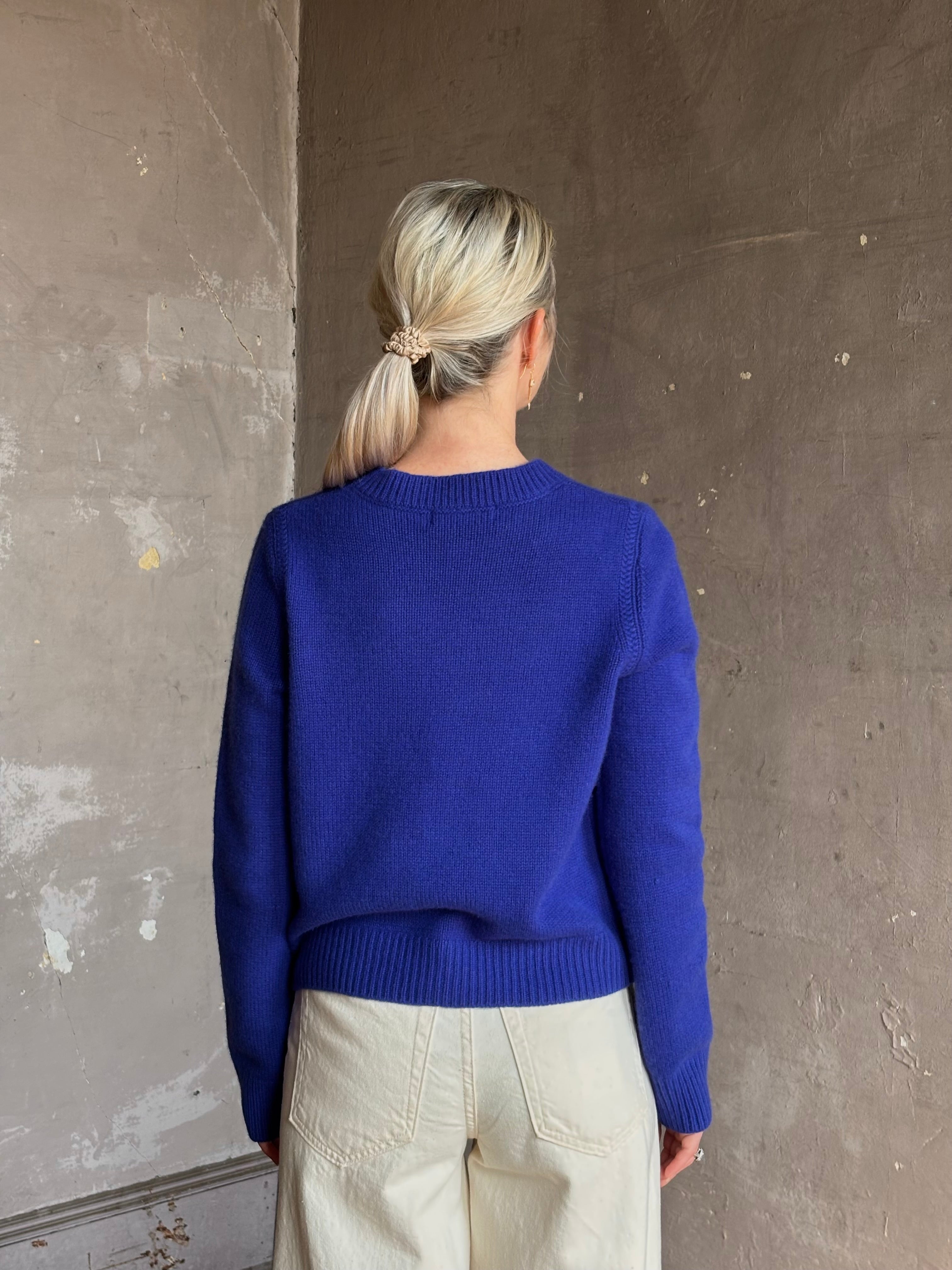 Mature woman wearing a vibrant cobalt blue Sablyn crewneck knit shrunken crewneck long sleeve cashmere sweater 