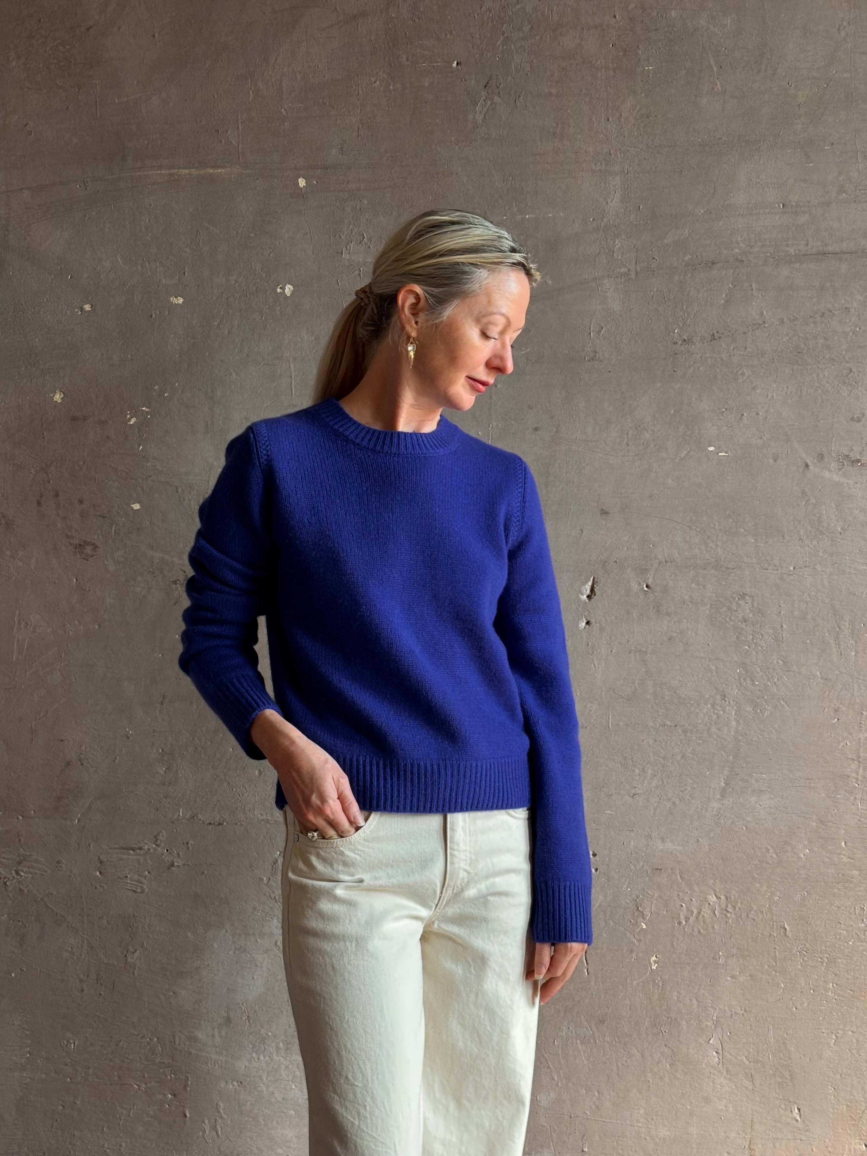 Mature woman wearing a vibrant cobalt blue Sablyn crewneck knit shrunken crewneck long sleeve cashmere sweater 