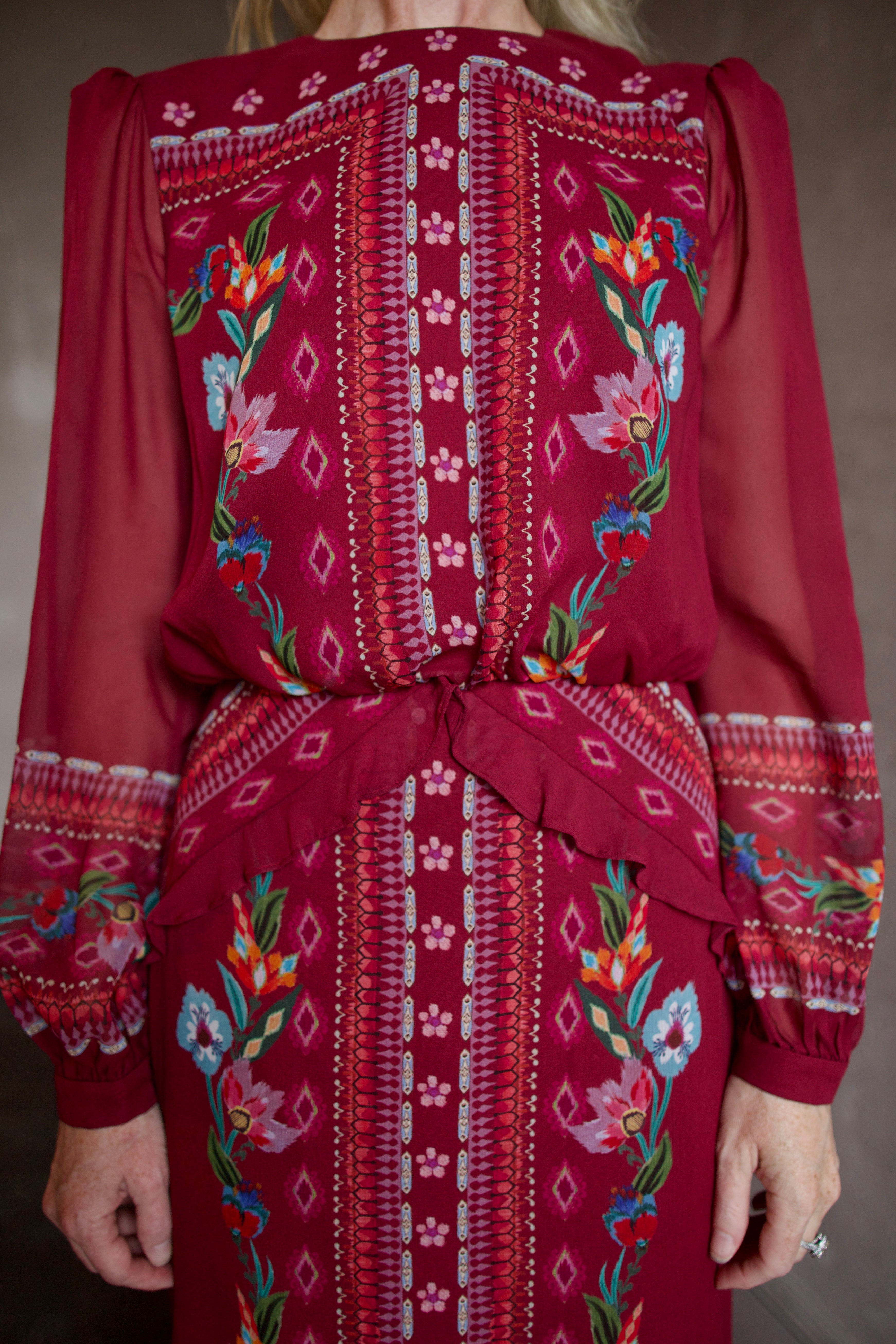 Model wearing Saloni Isa Long-C Dress in Cordia Vines. Dress features sophisticated silk fabrication with elegant long sleeves, delicate ruffle detailing, and intricate pattern styling.