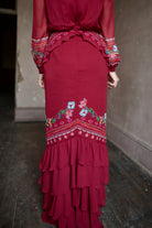 Mature woman wearing sophisticated Saloni Isa Long-C silk burgundy maxi Dress in Cordia Vines with long sleeves, delicate ruffle details and intricate floral pattern