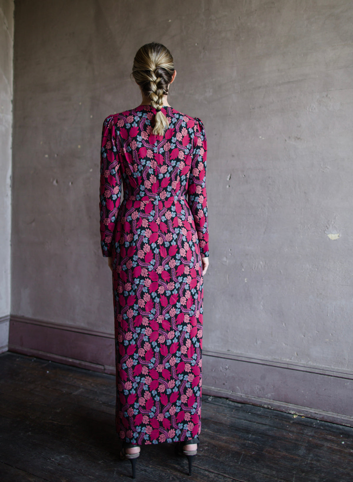 Image featuring a woman wearing the Jinx-C silk dress by Saloni with a crew neckline, long sleeves, and velvet trim cutouts down the front in a leaf print