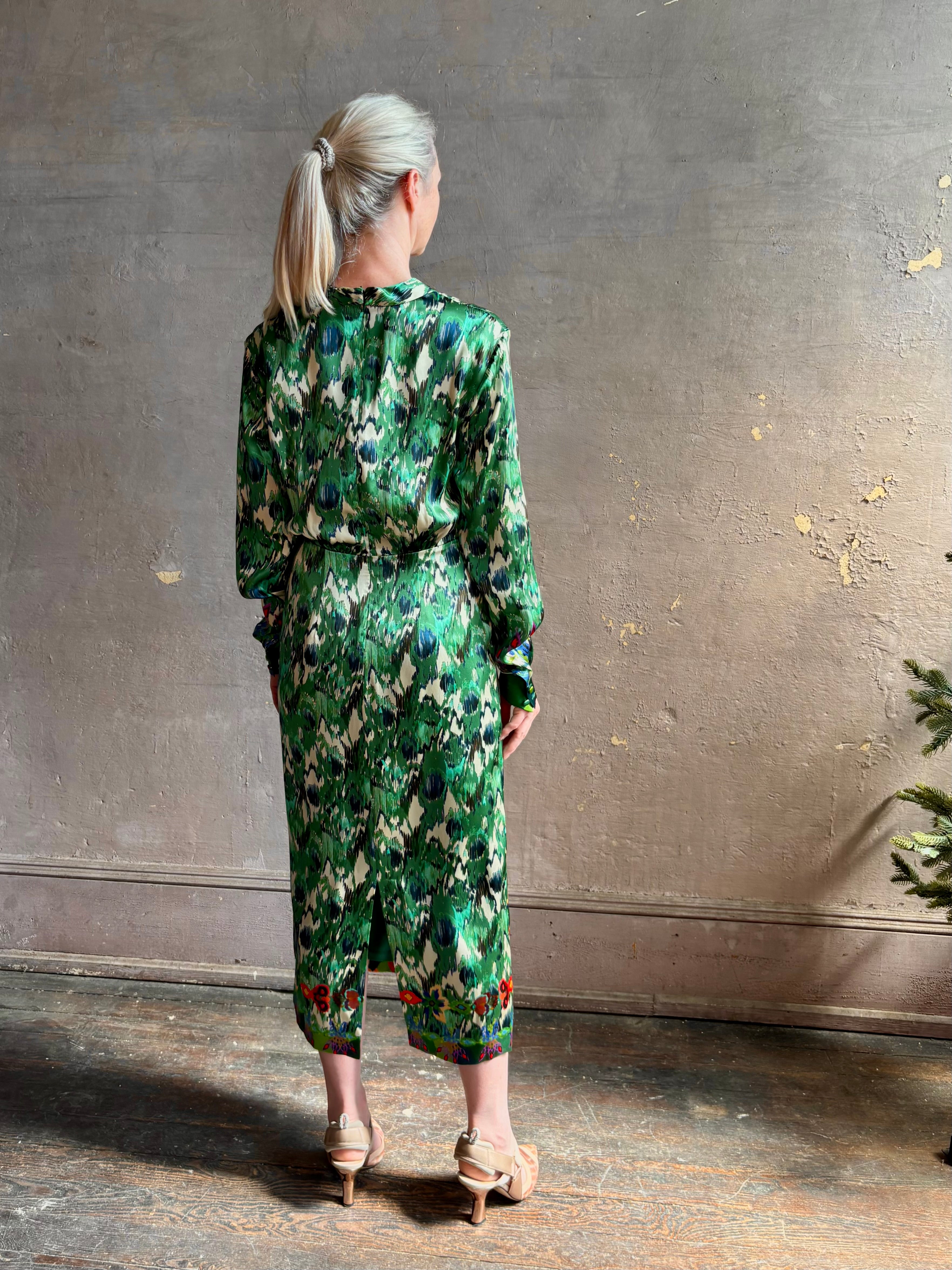 Mature woman wearing Saloni Mya silk long sleeve green floral midi dress with  broach gathered waist V-neck