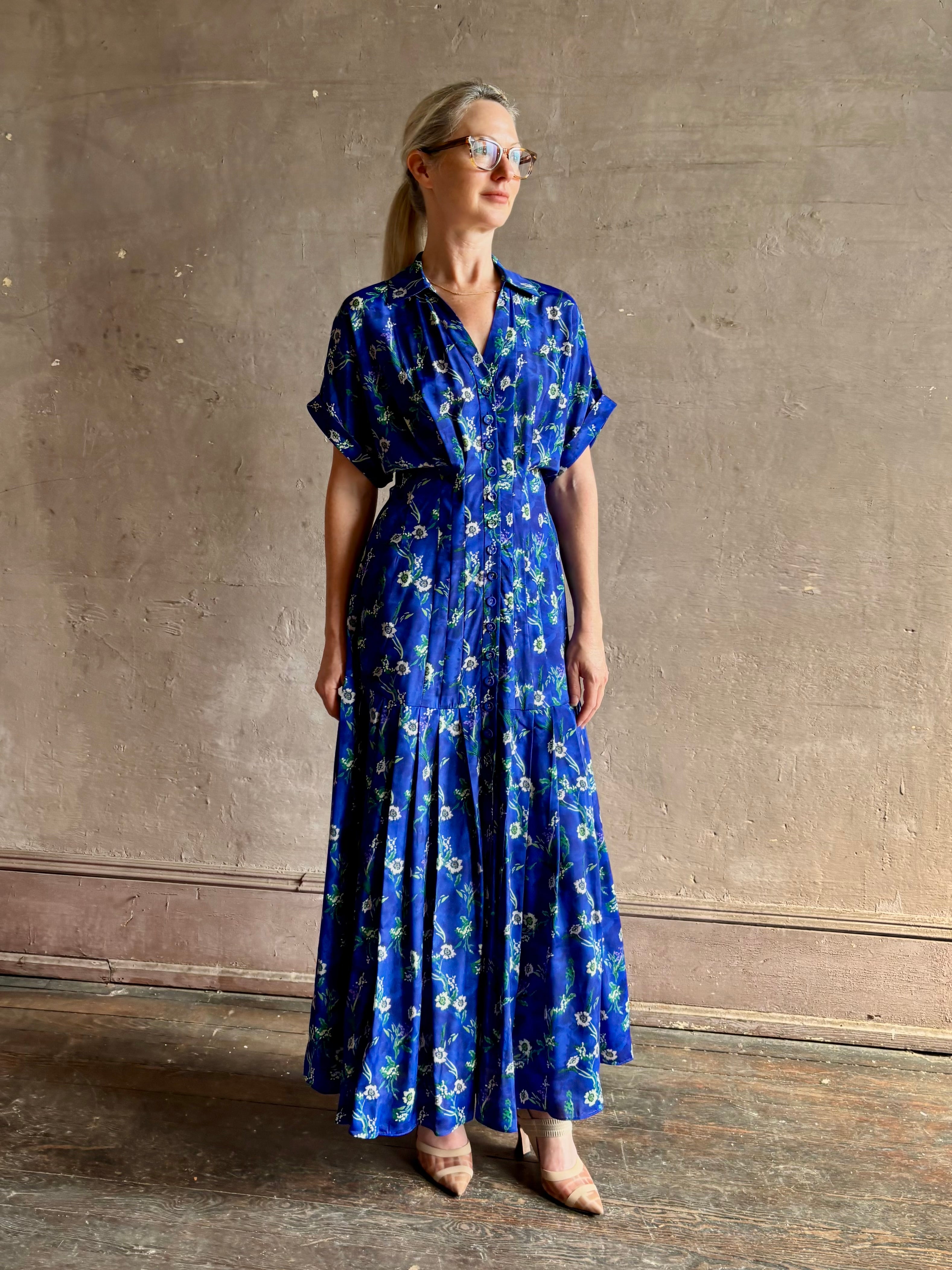 Woman wearing Saloni silk maxi Riya dress with short sleeves bouson top drop waist v-neck button front cobalt