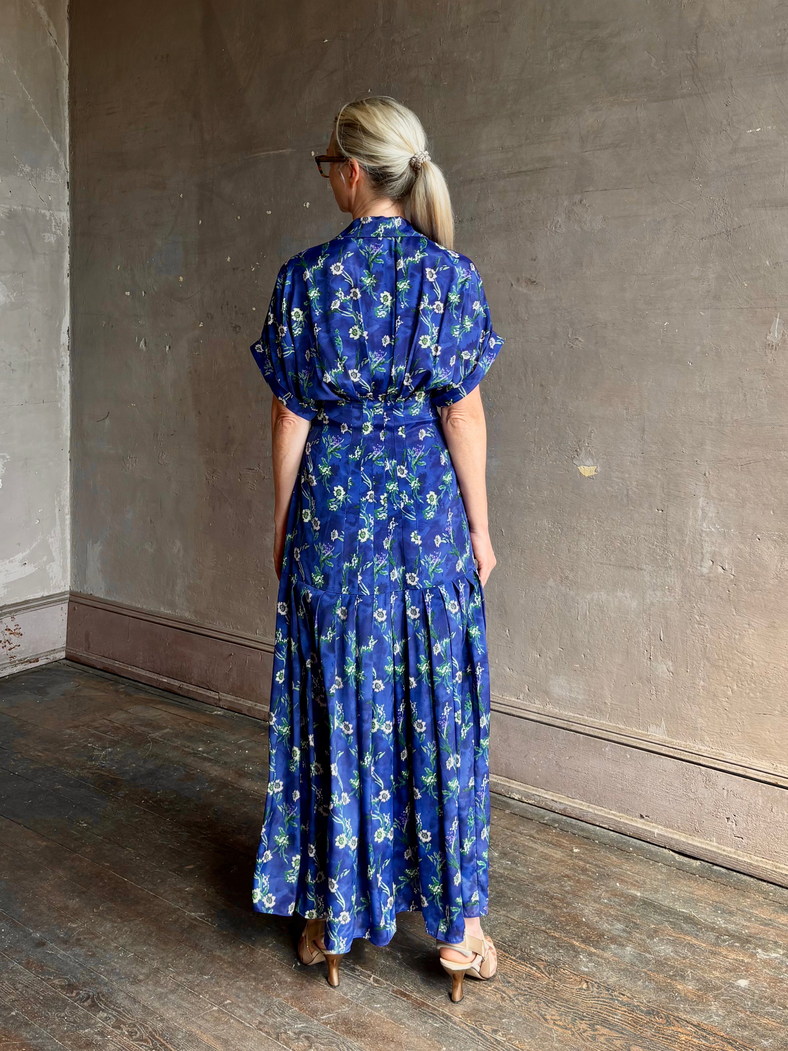Woman wearing Saloni silk maxi Riya dress with short sleeves bouson top drop waist v-neck button front cobalt