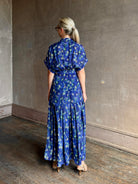 Woman wearing Saloni silk maxi Riya dress with short sleeves bouson top drop waist v-neck button front cobalt
