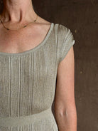 woman wearing saloni stardust cap sleeve floor-length ribbed knit dress front leg vent round neck fitted silver 