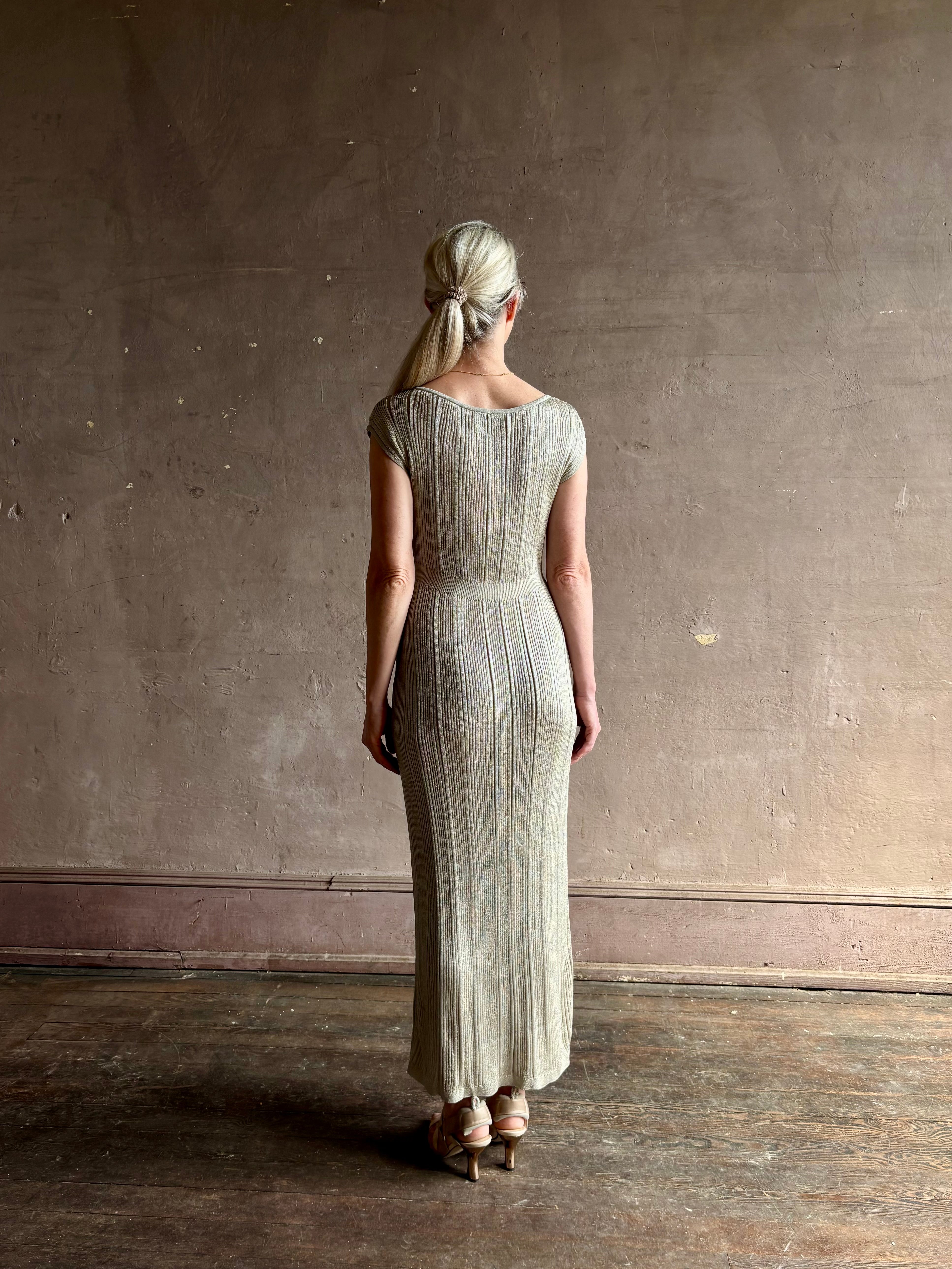woman wearing saloni stardust cap sleeve floor-length ribbed knit dress front leg vent round neck fitted silver 