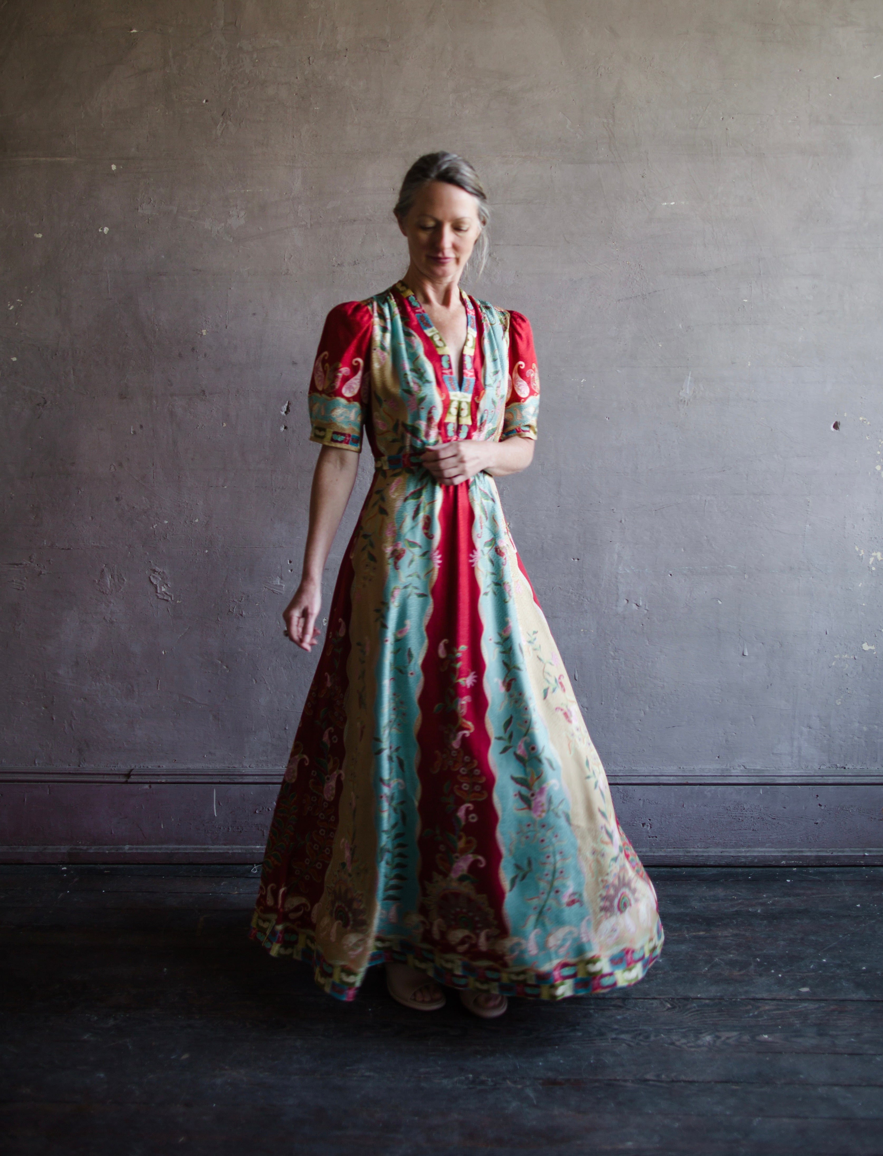 Mature woman wearing Saloni Tabitha silk maxi dress v-neck short sleeves empire waist red yellow aqua floral 