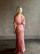 Mature woman wearing Saloni silk Winona Dress in Blush Marbling print V-back detail short sleeves empire waist Romantic occasion gown