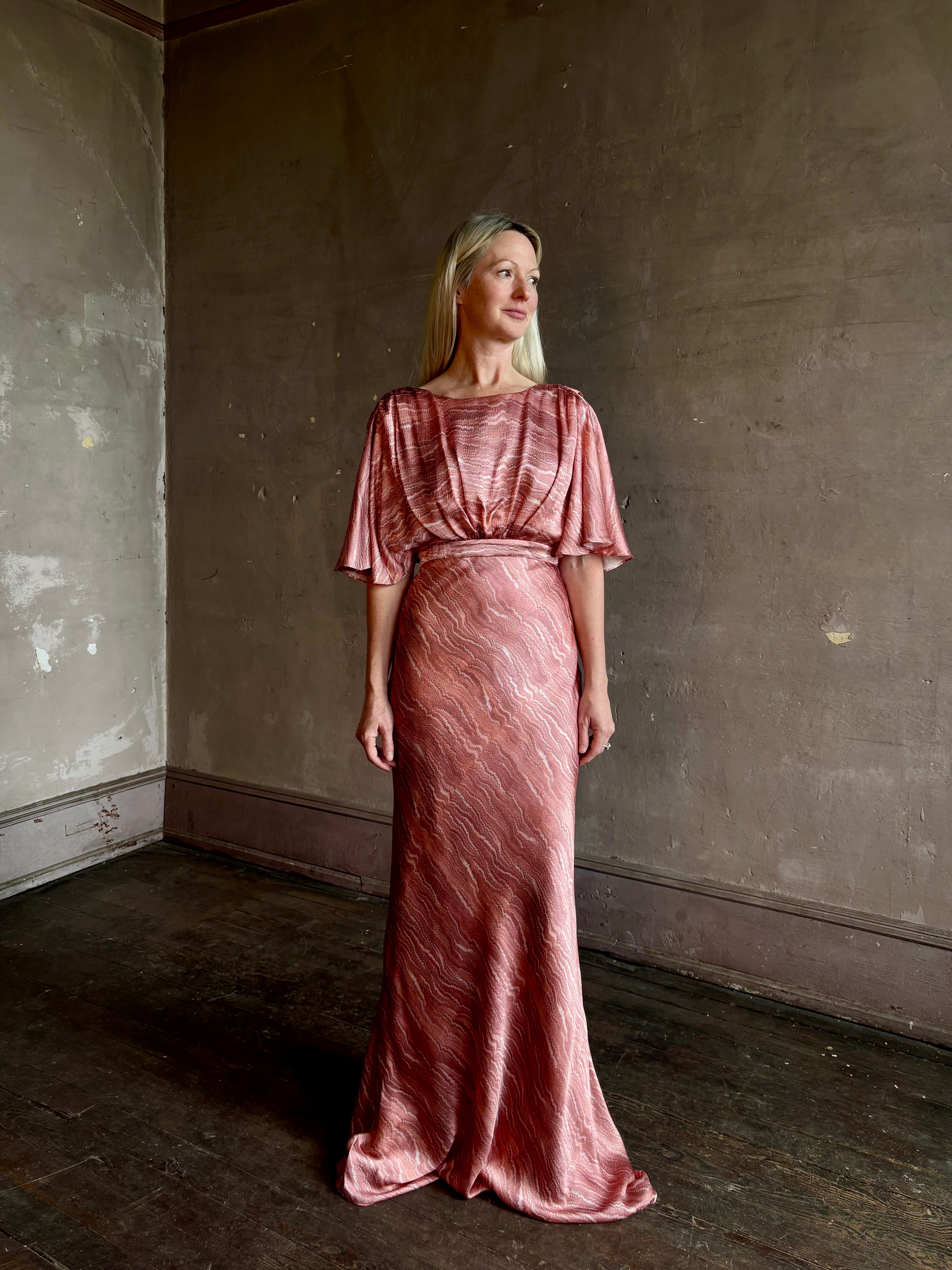 Mature woman wearing Saloni silk Winona Dress in Blush Marbling print V-back detail short sleeves empire waist Romantic occasion gown