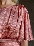 Mature woman wearing Saloni silk Winona Dress in Blush Marbling print V-back detail short sleeves empire waist Romantic occasion gown