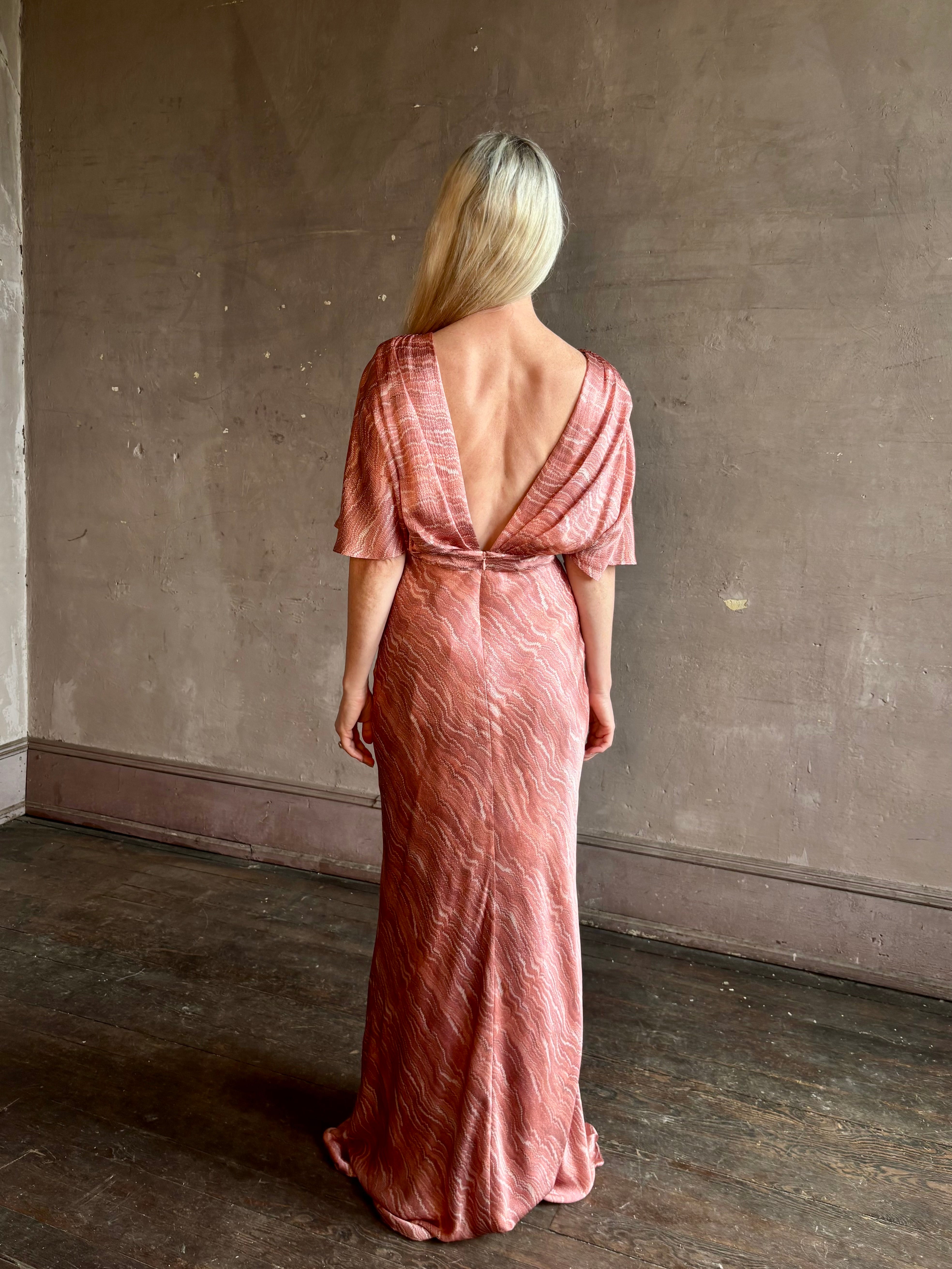 Mature woman wearing a pink long gown with a deep V-back and short sleeves Saloni Winona silk dress