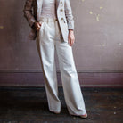woman wearing Grace Slvrlake cotton rigid denim high-rise, wide leg jeans with a double side seams, slanted side pockets in ecru.