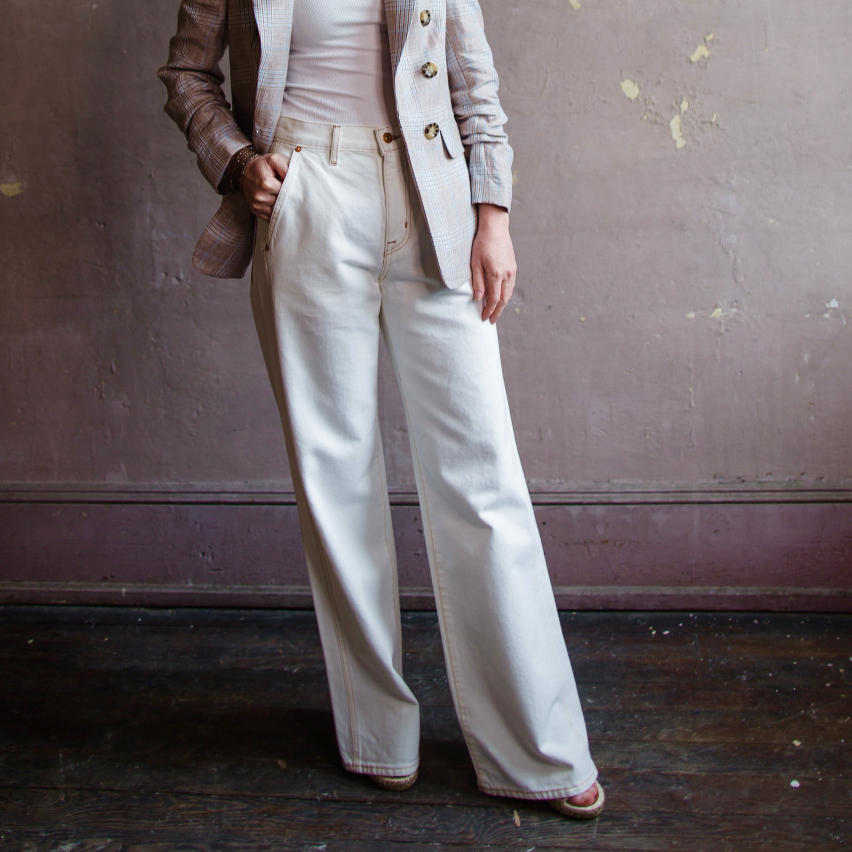 woman wearing Grace Slvrlake cotton rigid denim high-rise, wide leg jeans with a double side seams, slanted side pockets in ecru.