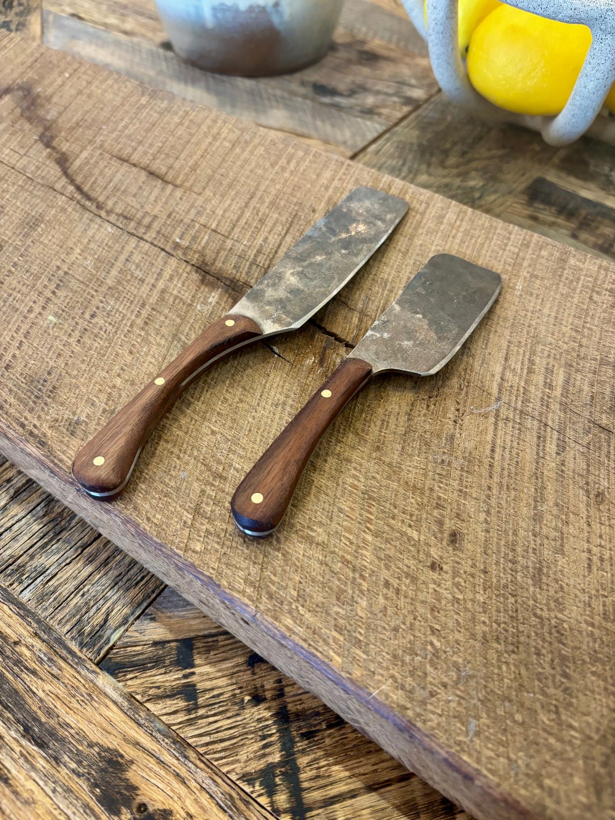 A small and large rustic modern charcuterie serving knife set with hand-forged steel blade and a walnut wooden handle hand crafted in USA