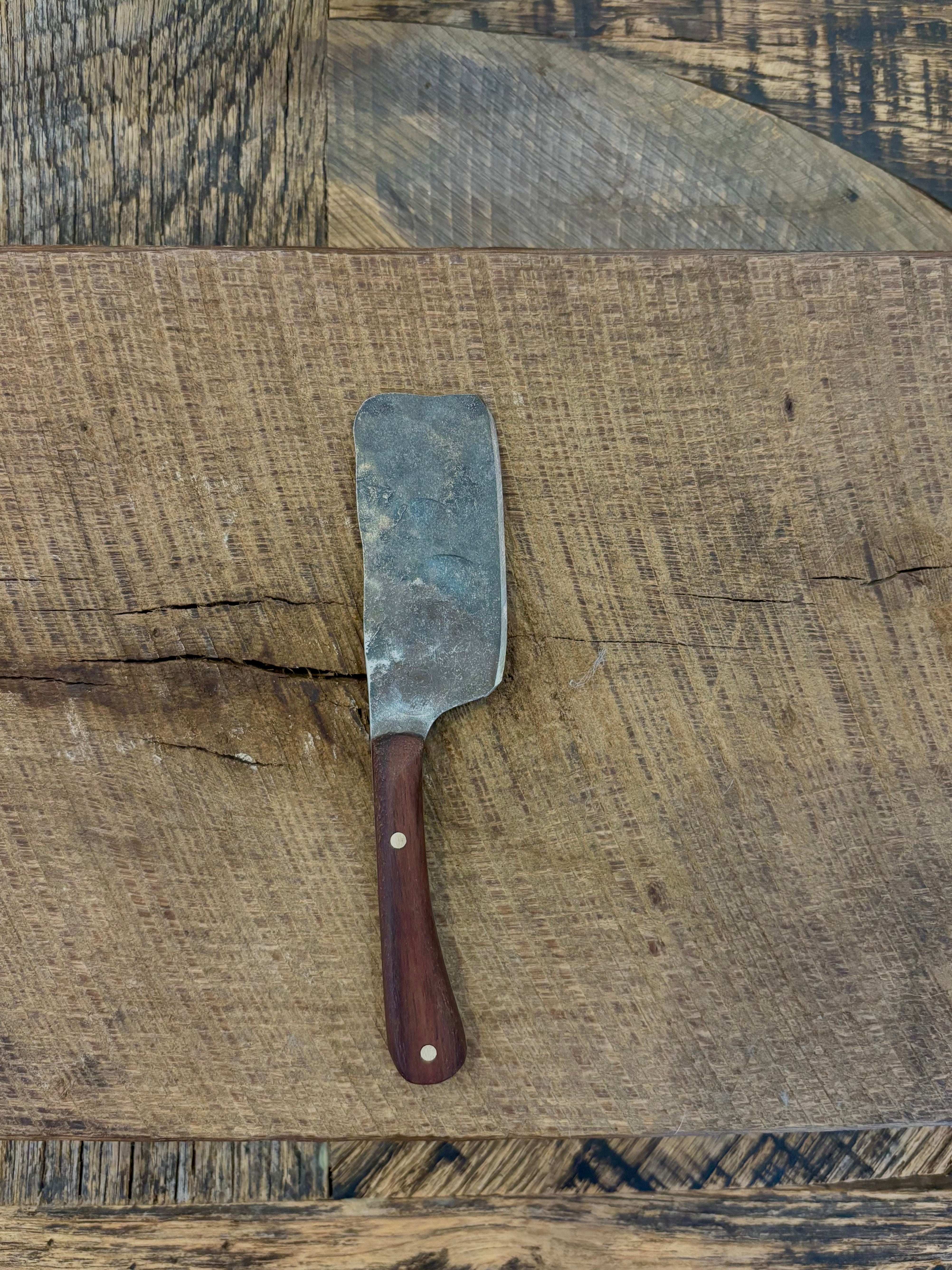 A small rustic modern charcuterie serving knife with hand-forged steel blade and a walnut wooden handle hand crafted in USA