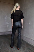 Model wearing SPRWMN Black Ankle Flare Leather Pants - Designer Mid-Rise Stretch Leather