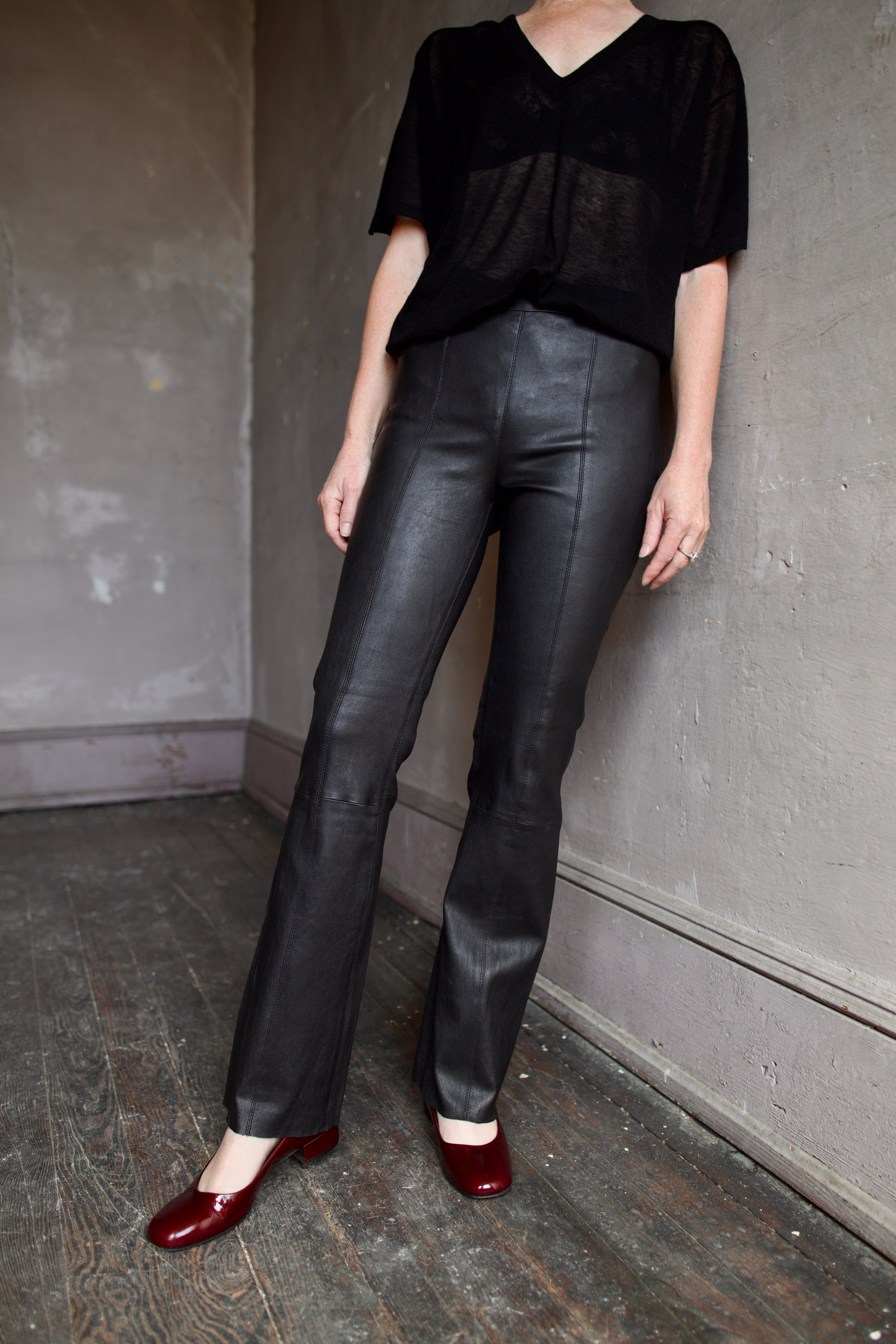 Model wearing SPRWMN Black Ankle Flare Leather Pants - Designer Mid-Rise Stretch Leather