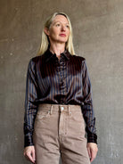 woman wearing luxury brand SPRWMN Fonda silk button up shirt in a black and brown stripe modern classic.