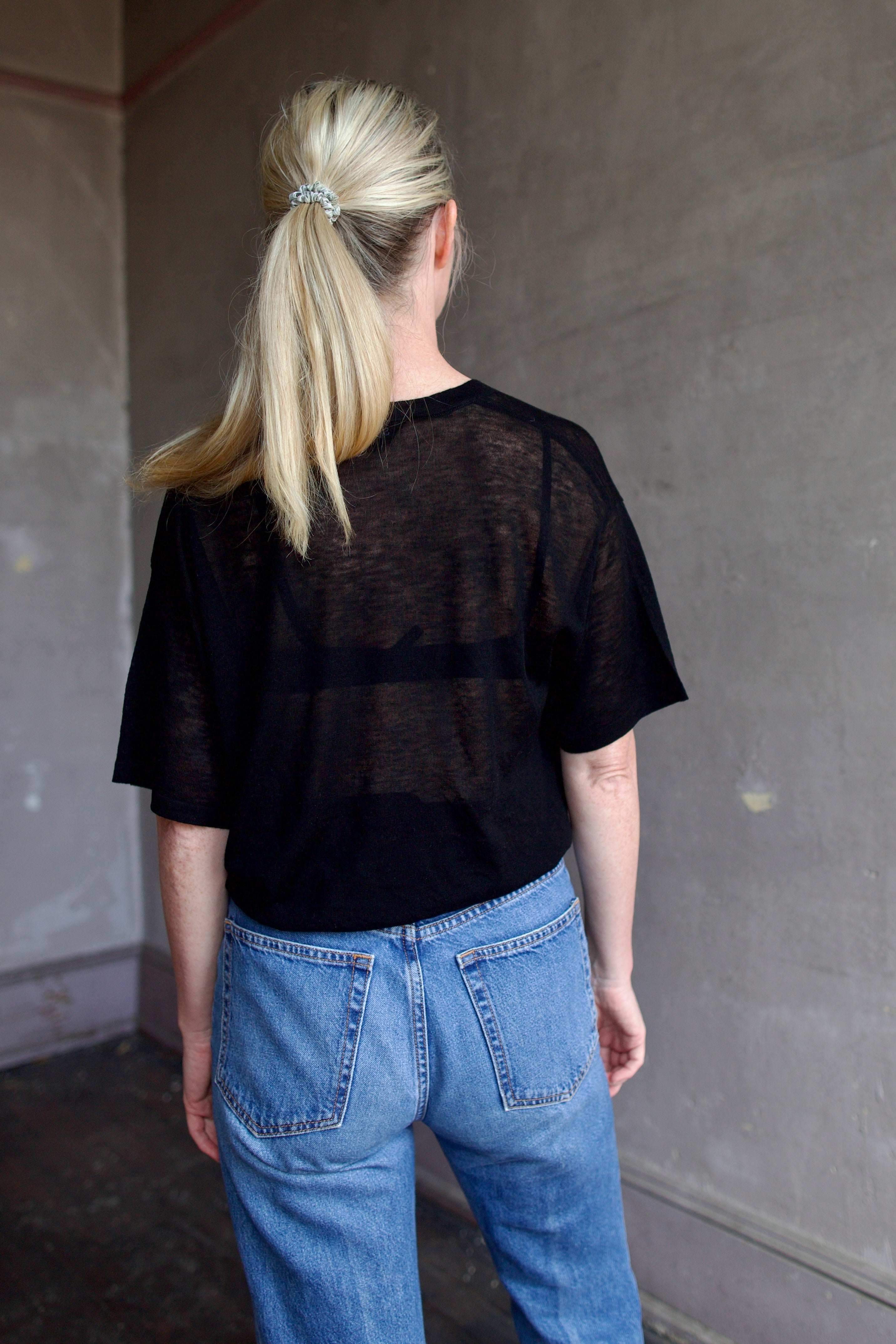 Model wearing SPRWMN Black V Neck Wool Tee - Designer Sheer Wool Short Sleeve Top