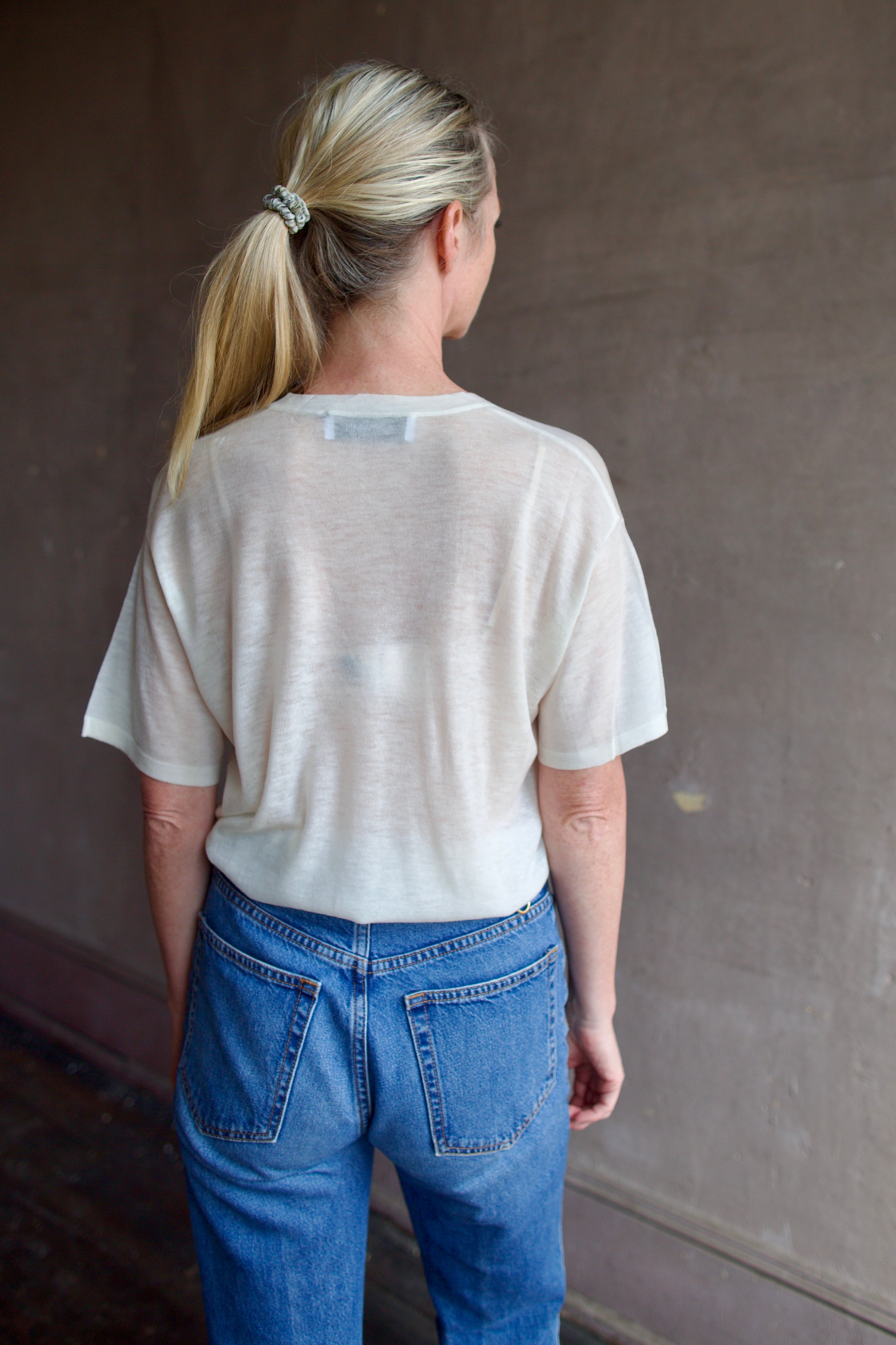Model wearing SPRWMN Ivory V Neck Wool Tee - Designer Sheer Wool Short Sleeve Top