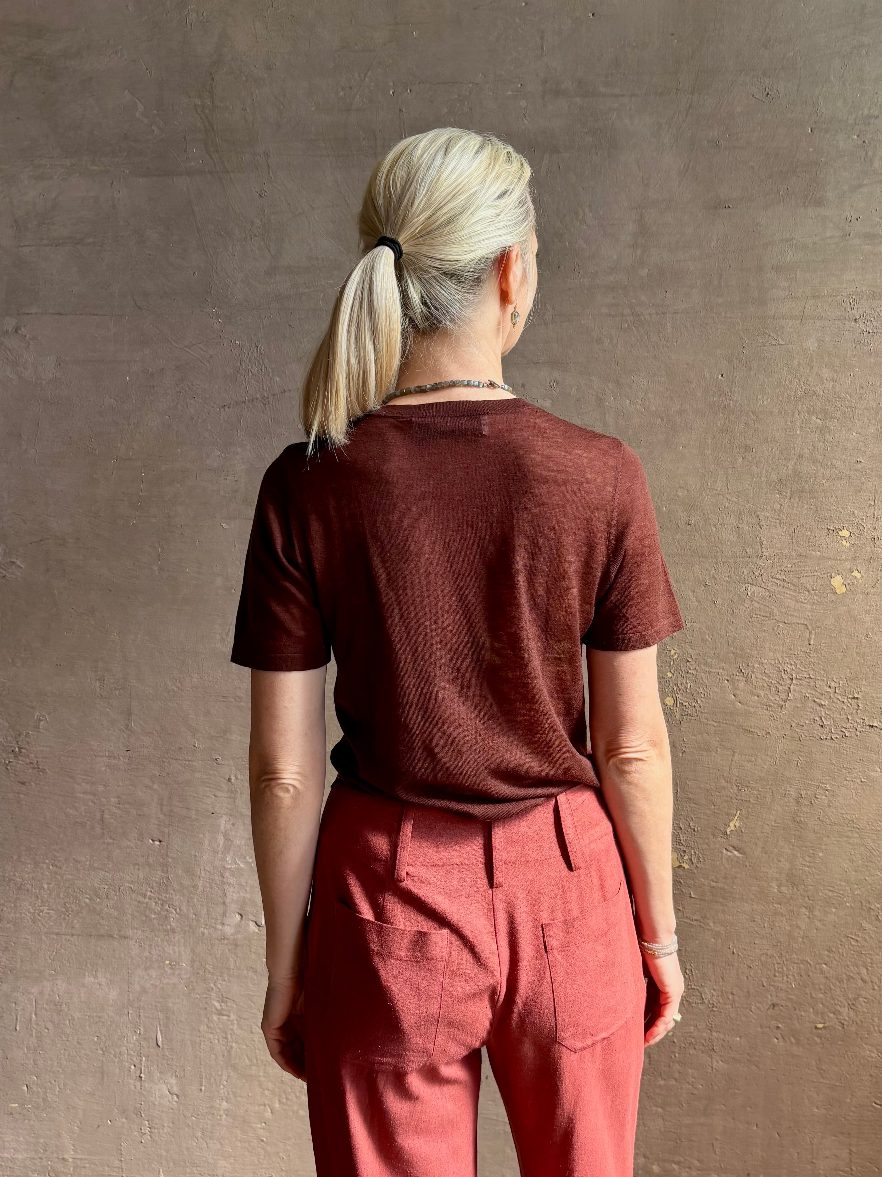Mature woman wearing premium polished layer SPRWMN classic brown wool tee shirt with crew neck and short sleeves and very light weight for a summer elevated basic or cool weather layering