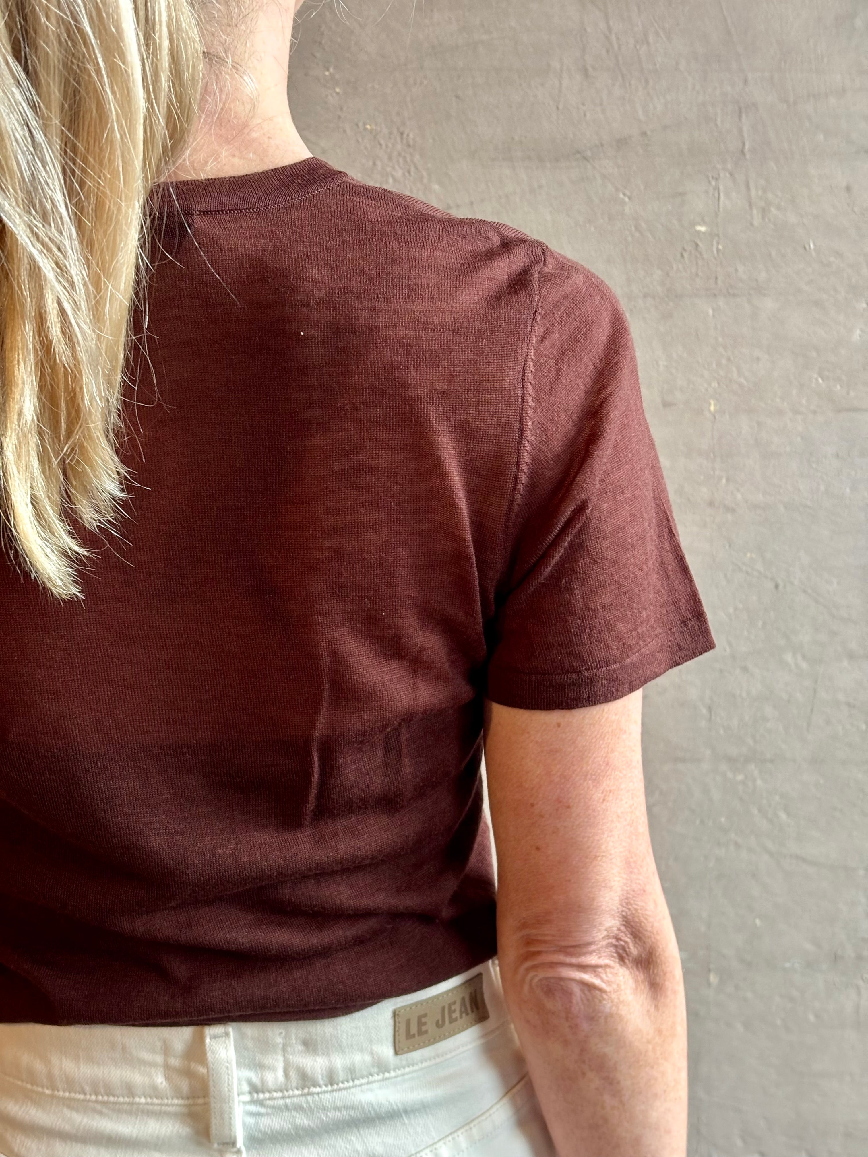 Image of woman wearing premium polished layer SPRWMN classic brown wool tee shirt with crew neck and short sleeve