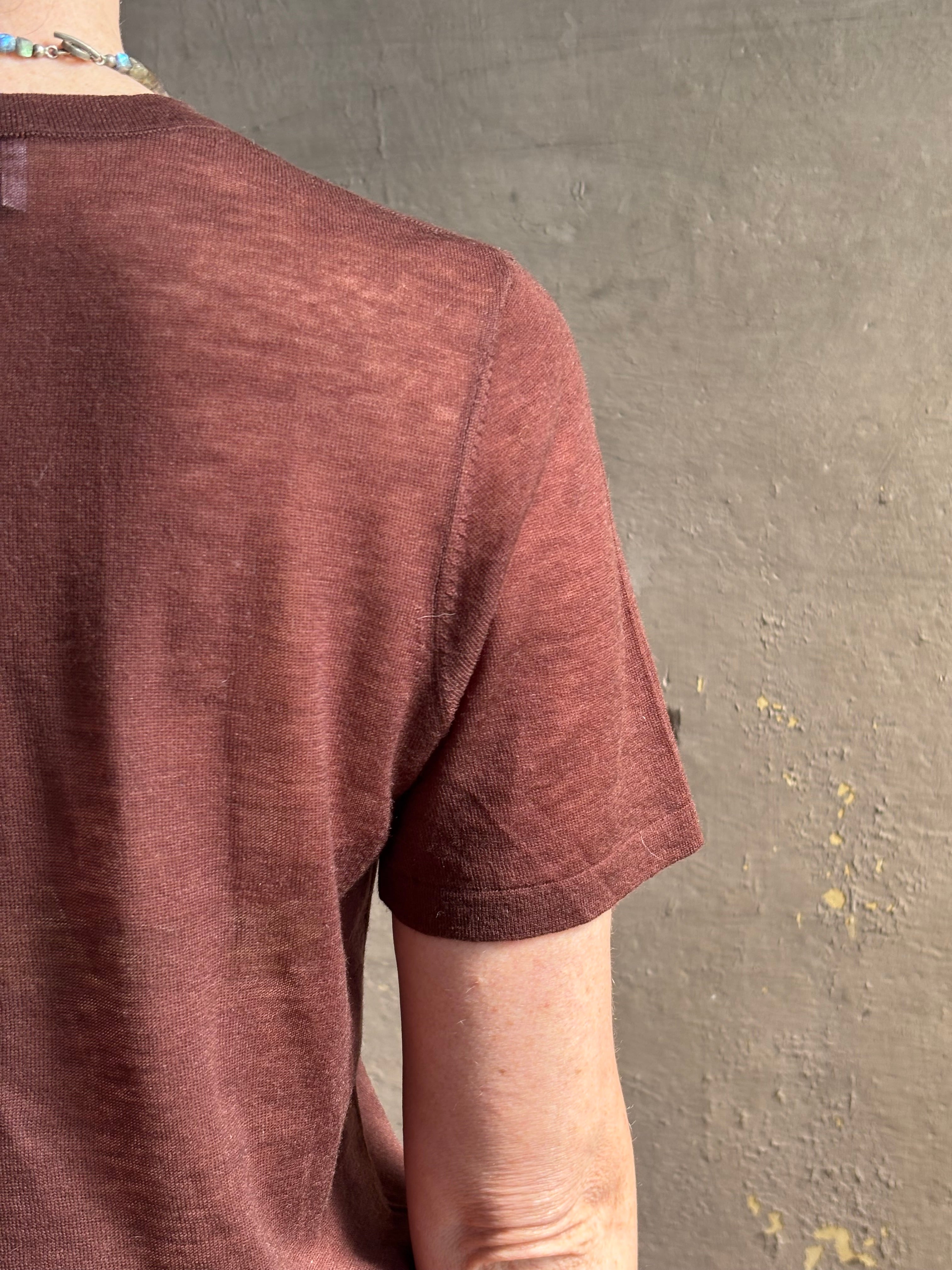 Mature woman wearing premium polished layer SPRWMN classic brown wool tee shirt with crew neck and short sleeves and very light weight for a summer elevated basic or cool weather layering