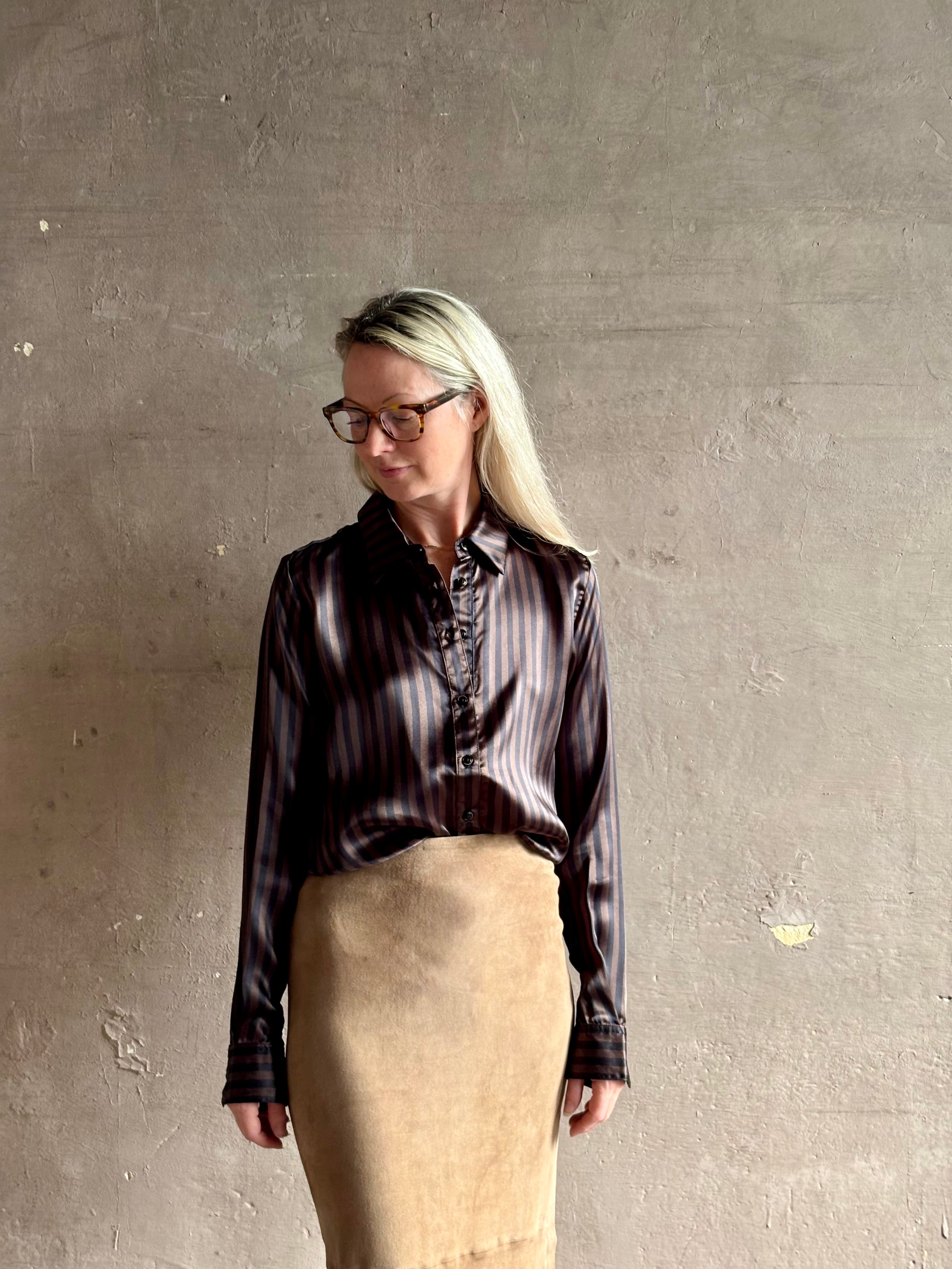 woman wearing luxury brand SPRWMN Fonda silk button up shirt in a black and brown stripe modern classic