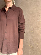 Mature woman wearing elevated casual wear button front Fonda top by SPRWMN in chocolate brown cashmere with long sleeves and a collar