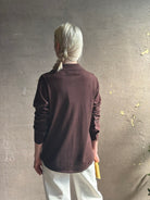 Mature woman wearing elevated casual wear button front Fonda top by SPRWMN in chocolate brown cashmere with long sleeves and a collar