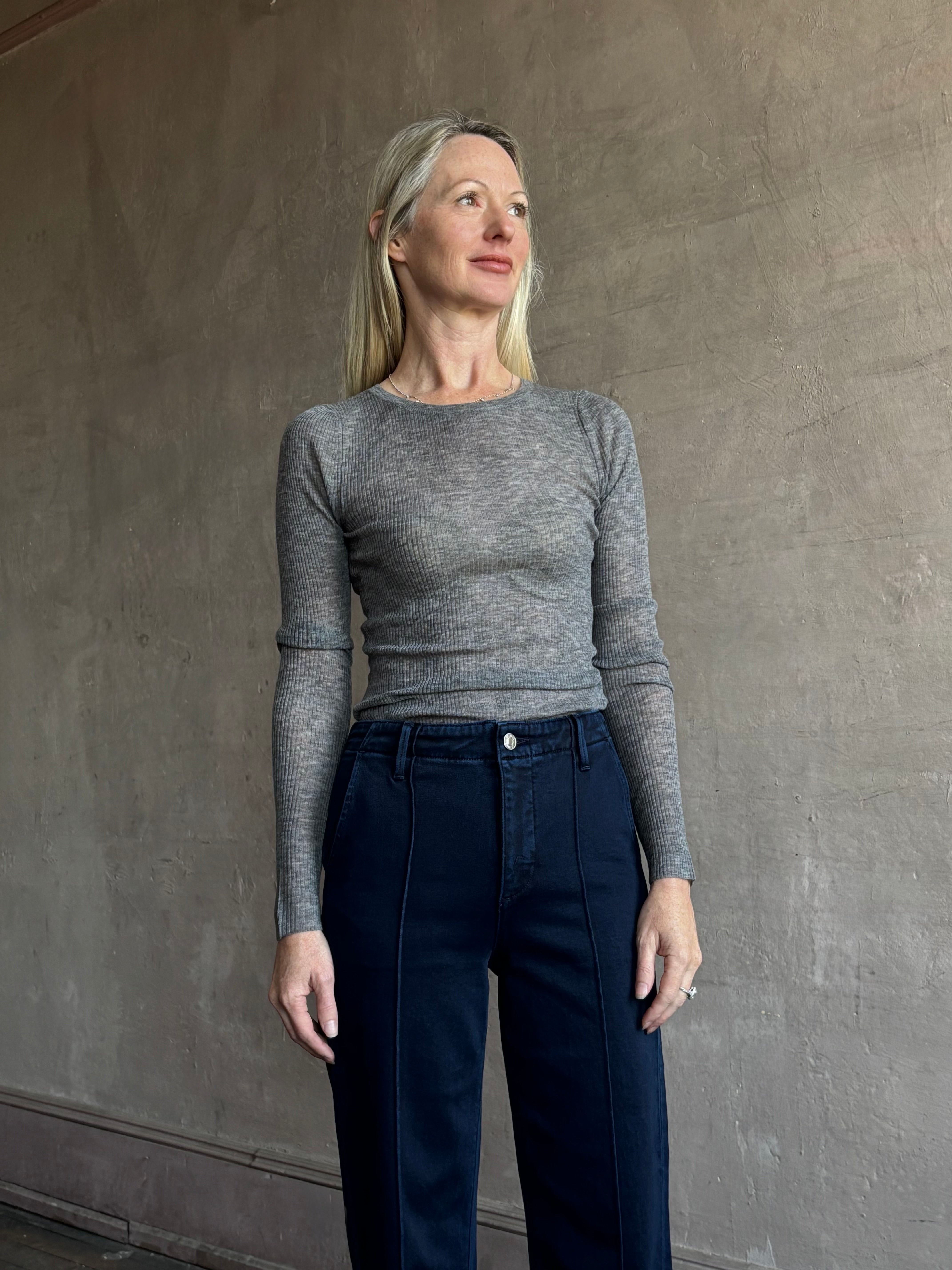 Image of mature woman wearing luxury women's clothing SPRWMN long sleeve baby tee with subtle transparency and lightweight knit