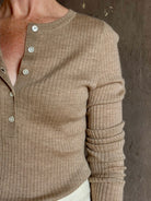 Mature woman wearing SPRWMN beige ribbed round neck cashmere henley top with long sleeves elevated casual wear