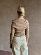 Mature woman wearing SPRWMN beige ribbed round neck cashmere henley top with long sleeves elevated casual wear