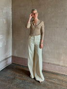 Mature woman wearing SPRWMN beige ribbed round neck cashmere henley top with long sleeves elevated casual wear