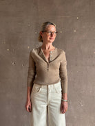 Mature woman wearing SPRWMN beige ribbed round neck cashmere henley top with long sleeves elevated casual wear