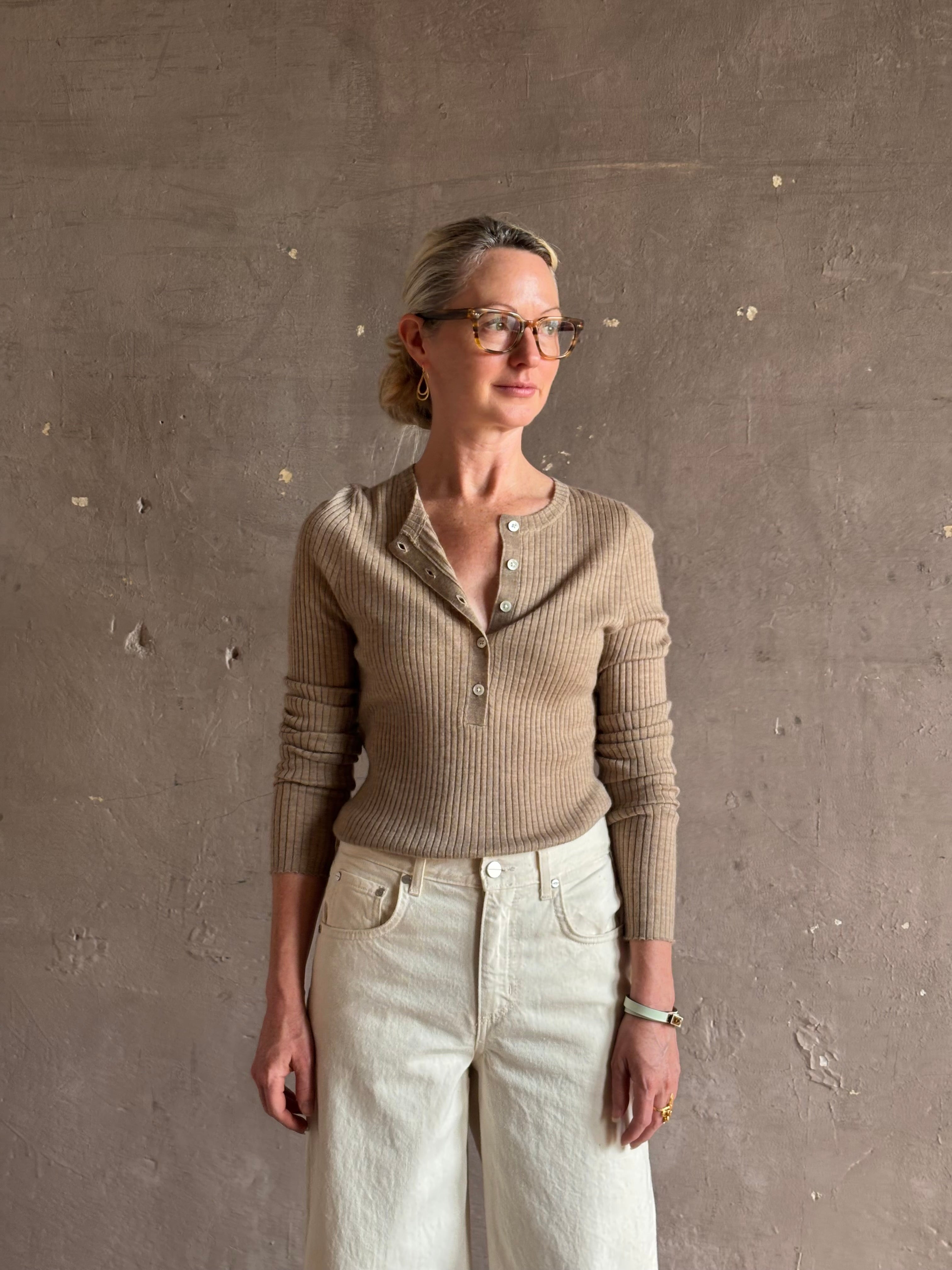 Mature woman wearing SPRWMN beige ribbed round neck cashmere henley top with long sleeves elevated casual wear