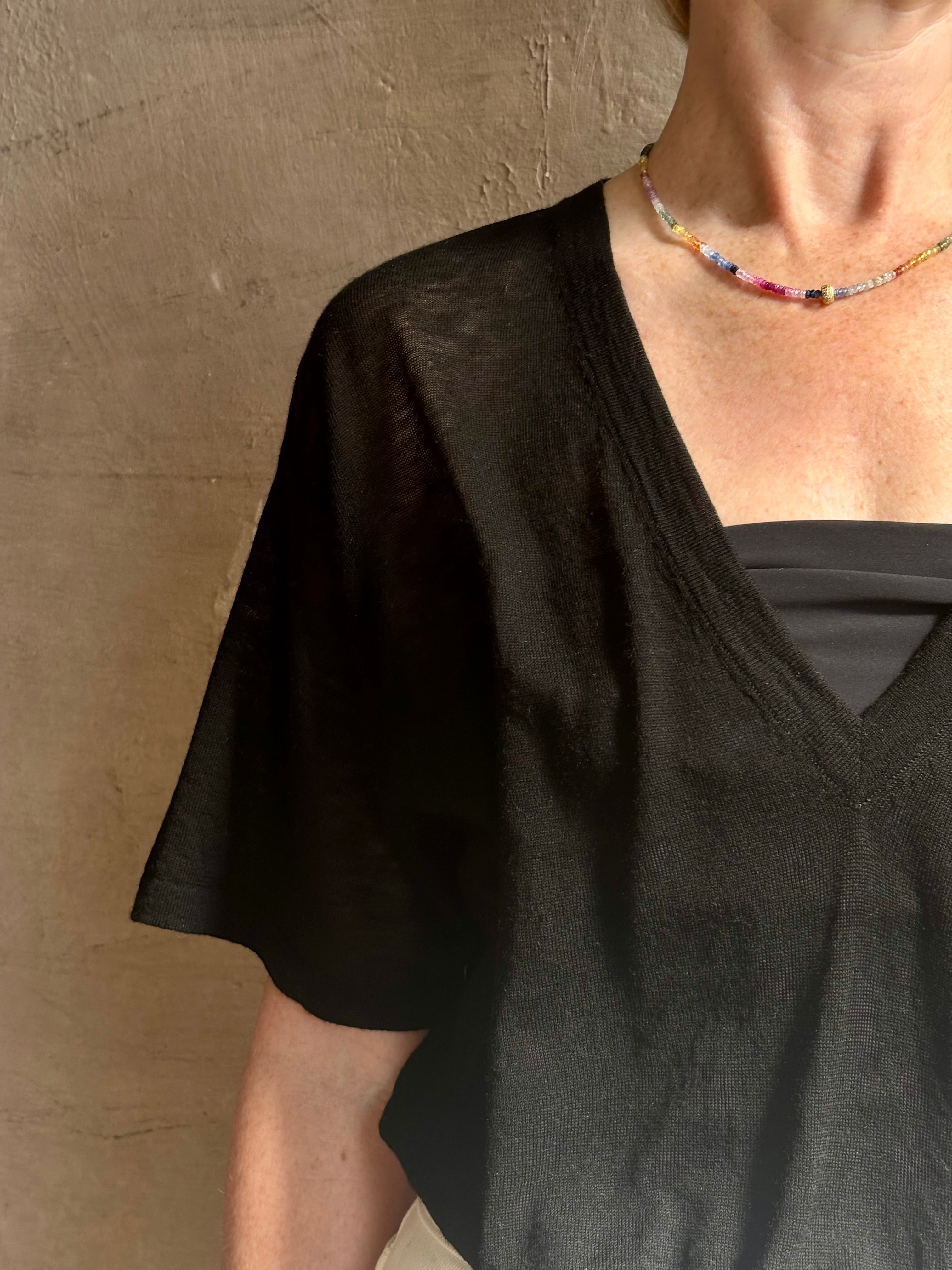 Mature woman wearing V Neck Tee from SPRWMN rendered in a timeless black and crafted from 100% premium sheer wool with fluid draping and short sleeve
