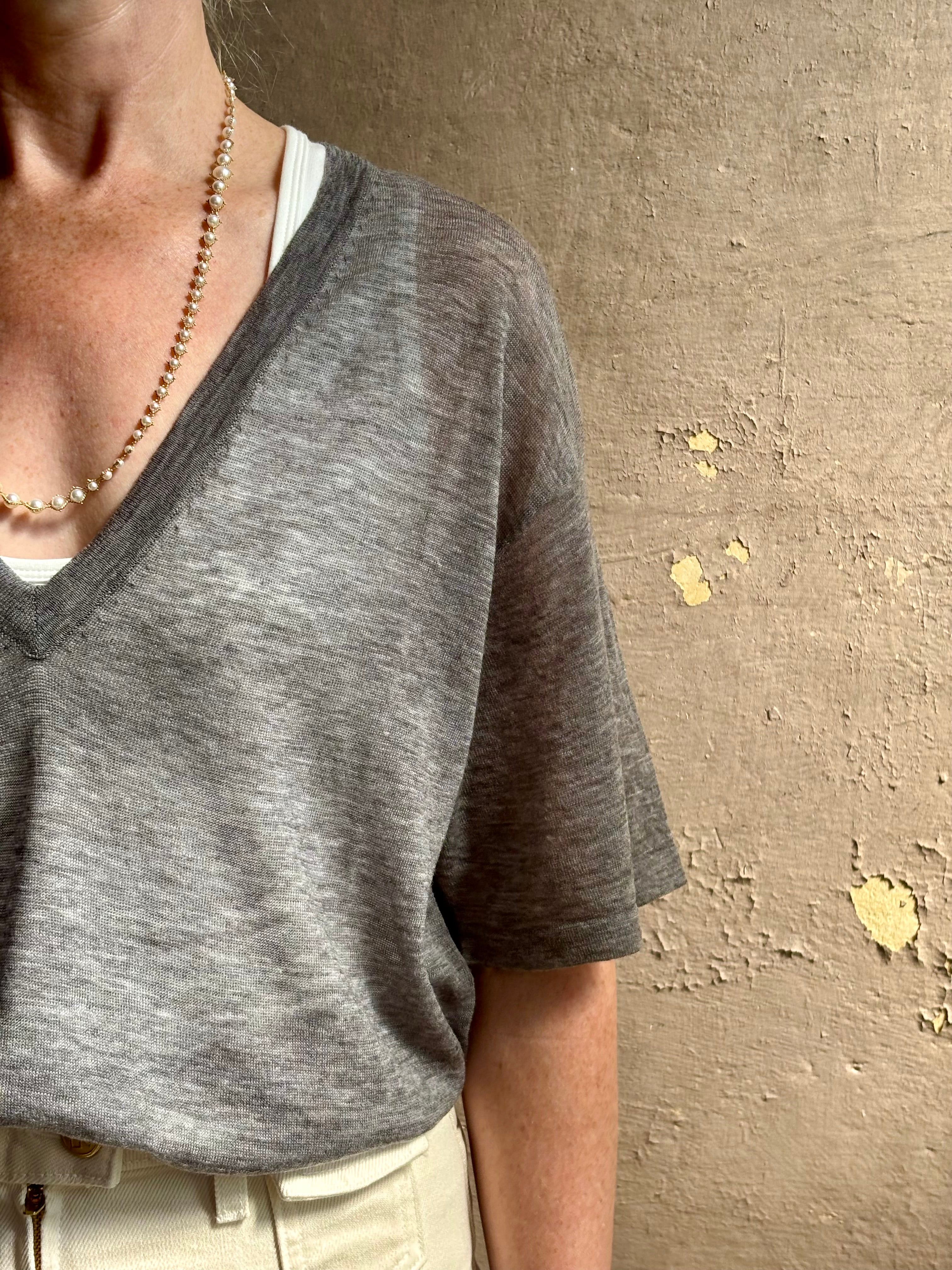 Mature woman wearing premium polished layer SPRWMN grey wool tee shirt with a v-neck and short sleeves